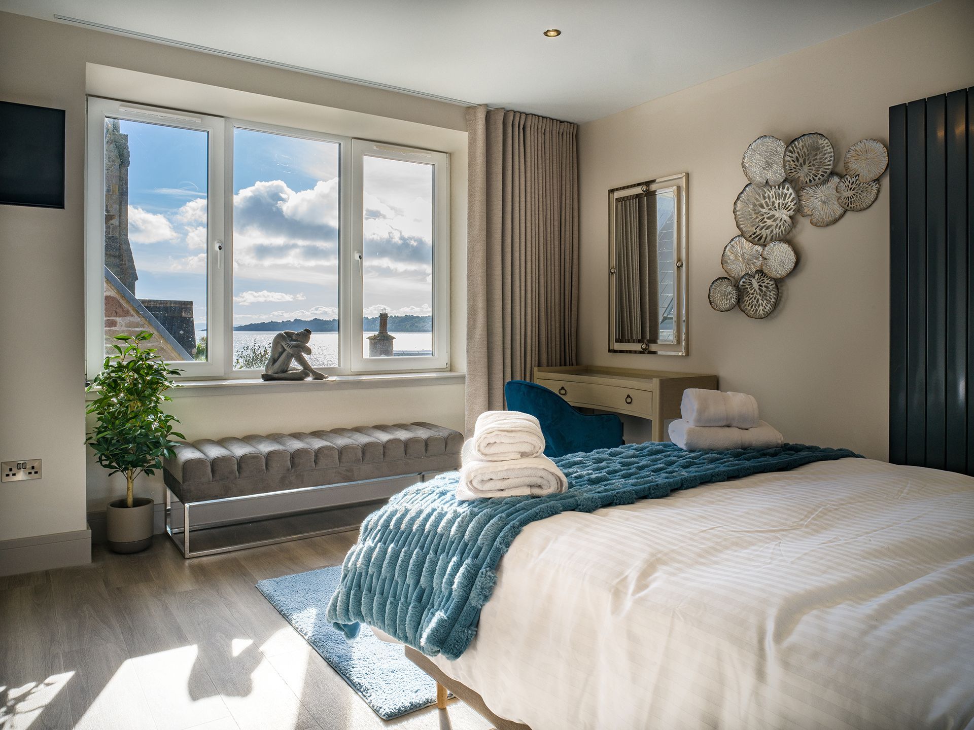 There is a large bed in the middle of the room with a large window.