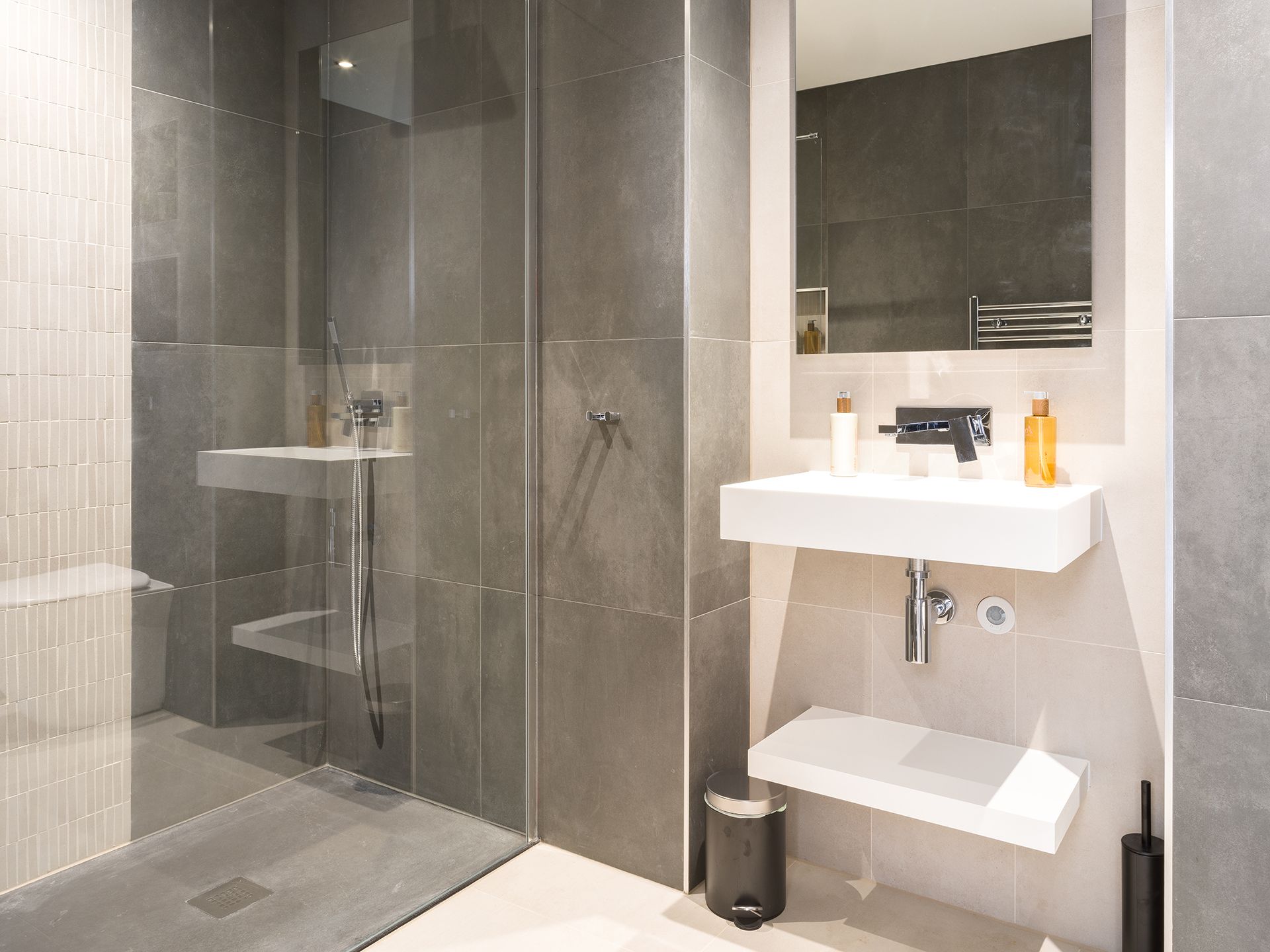 A bathroom with a sink , mirror and walk in shower.