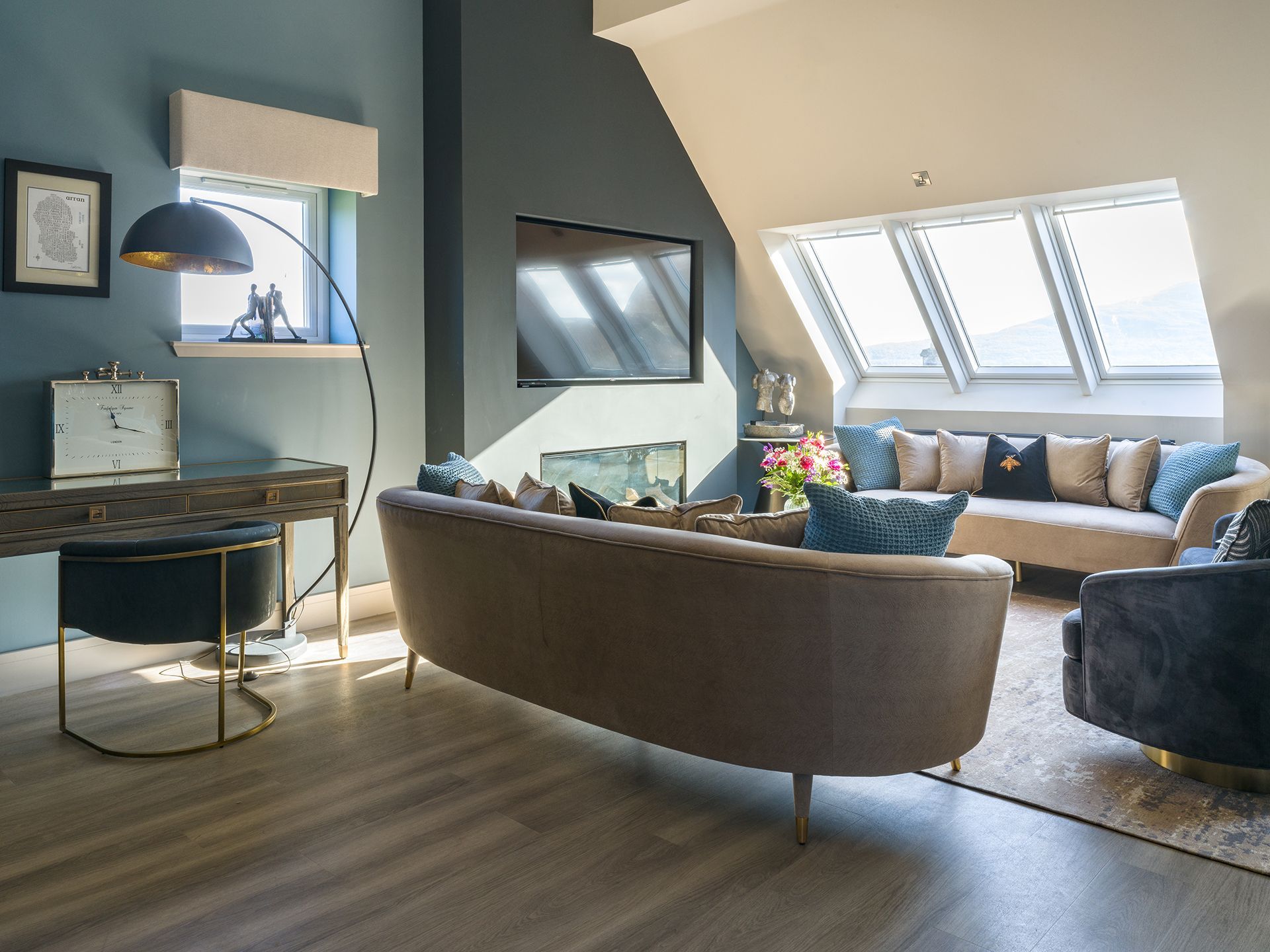 A living room with a couch , chair , desk and television.