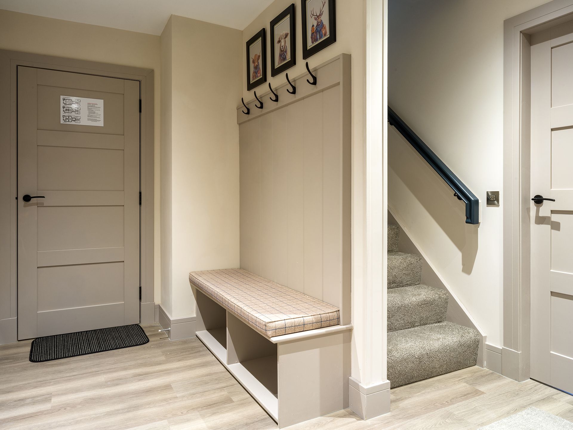 A hallway with a bench and stairs in a house.