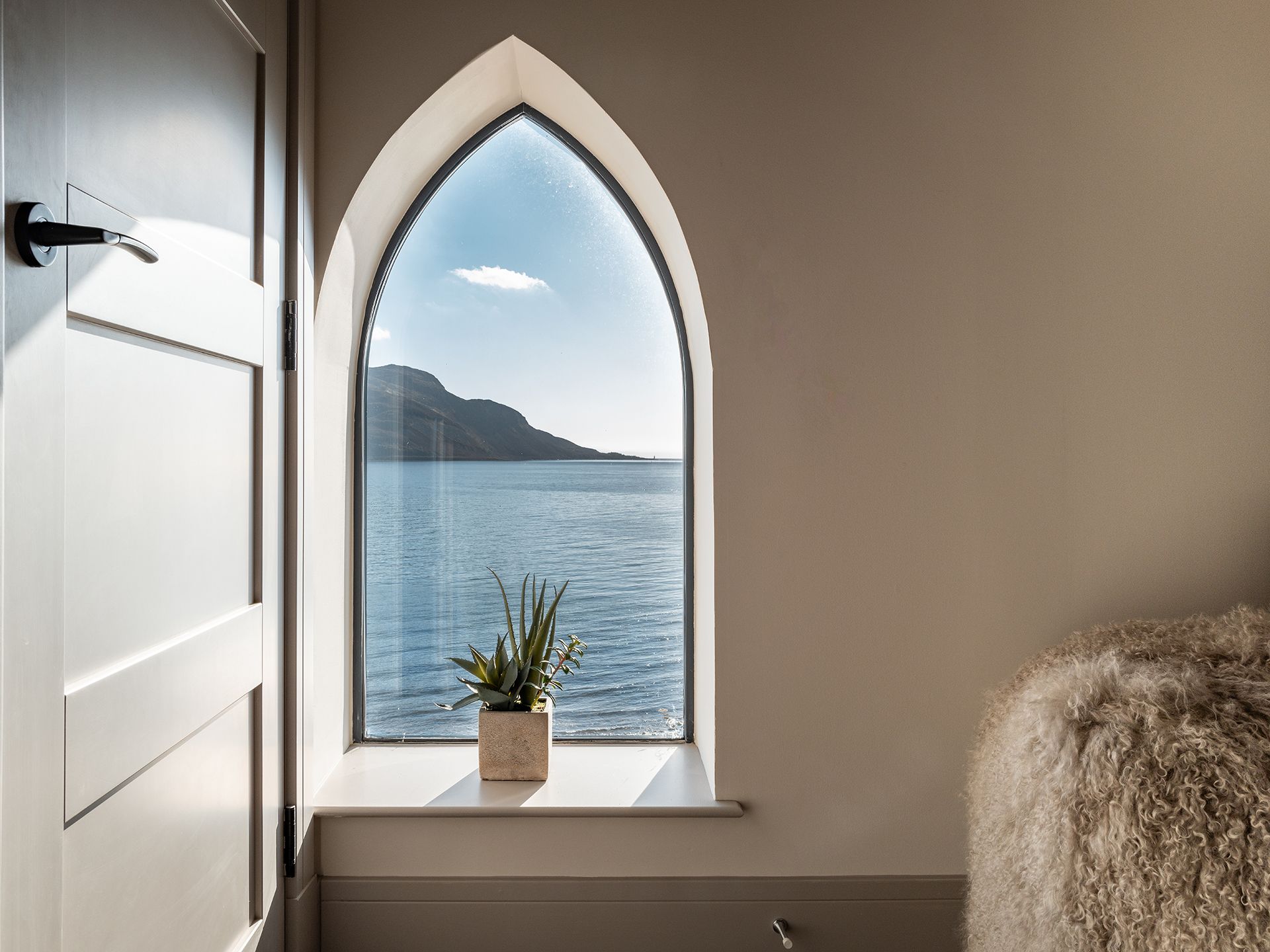 A window with a view of the ocean and mountains