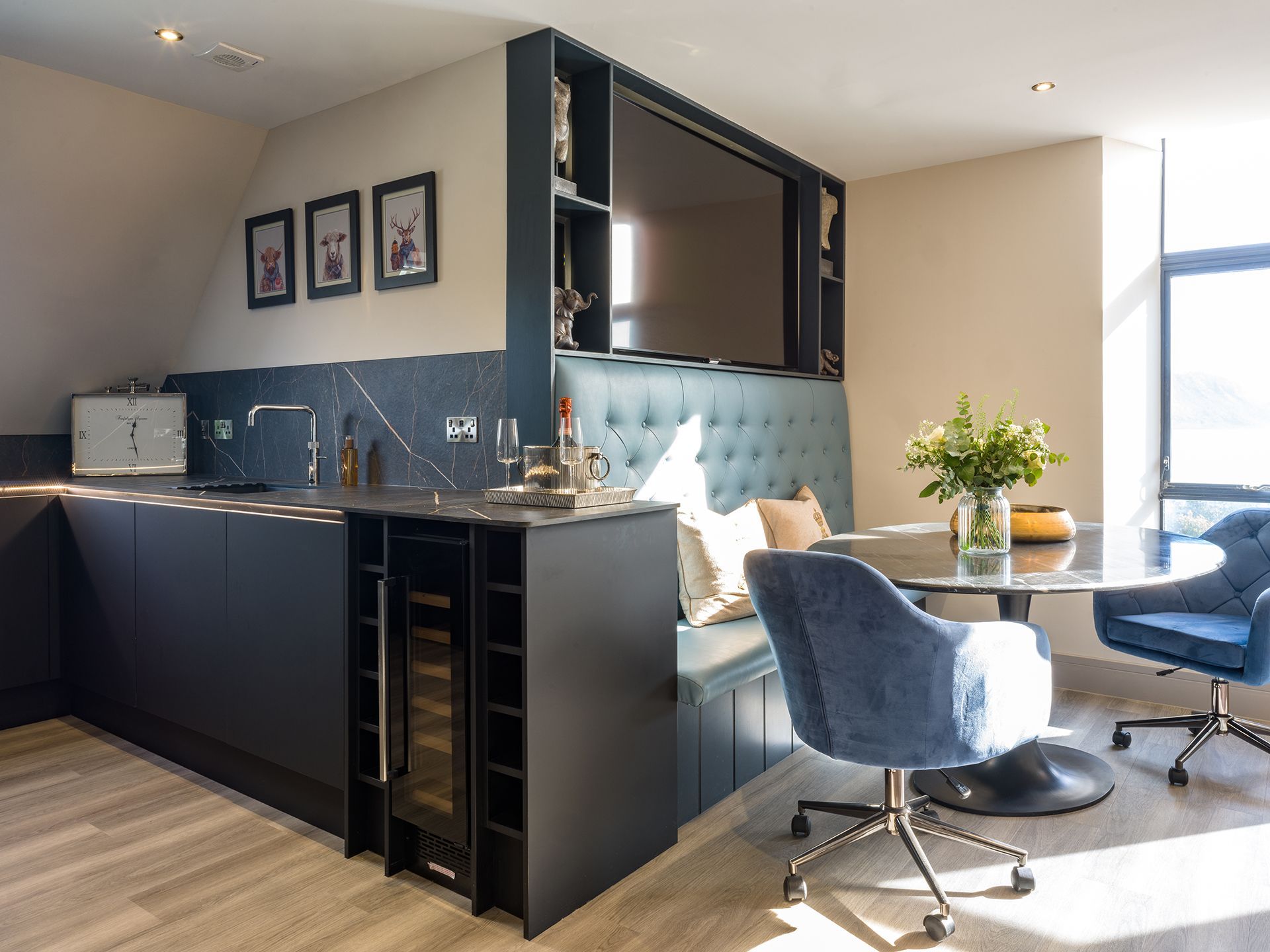 A living room with a table , chairs , and a television.