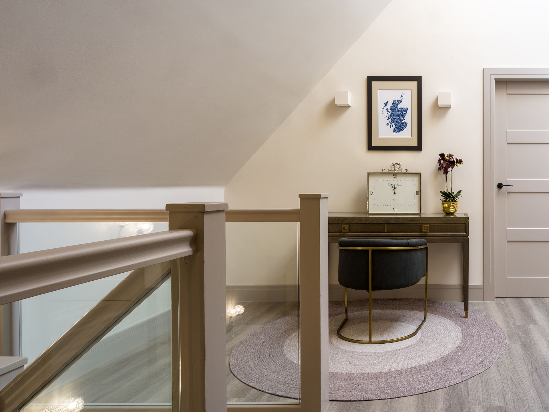 A room with a staircase and a desk with a clock on it