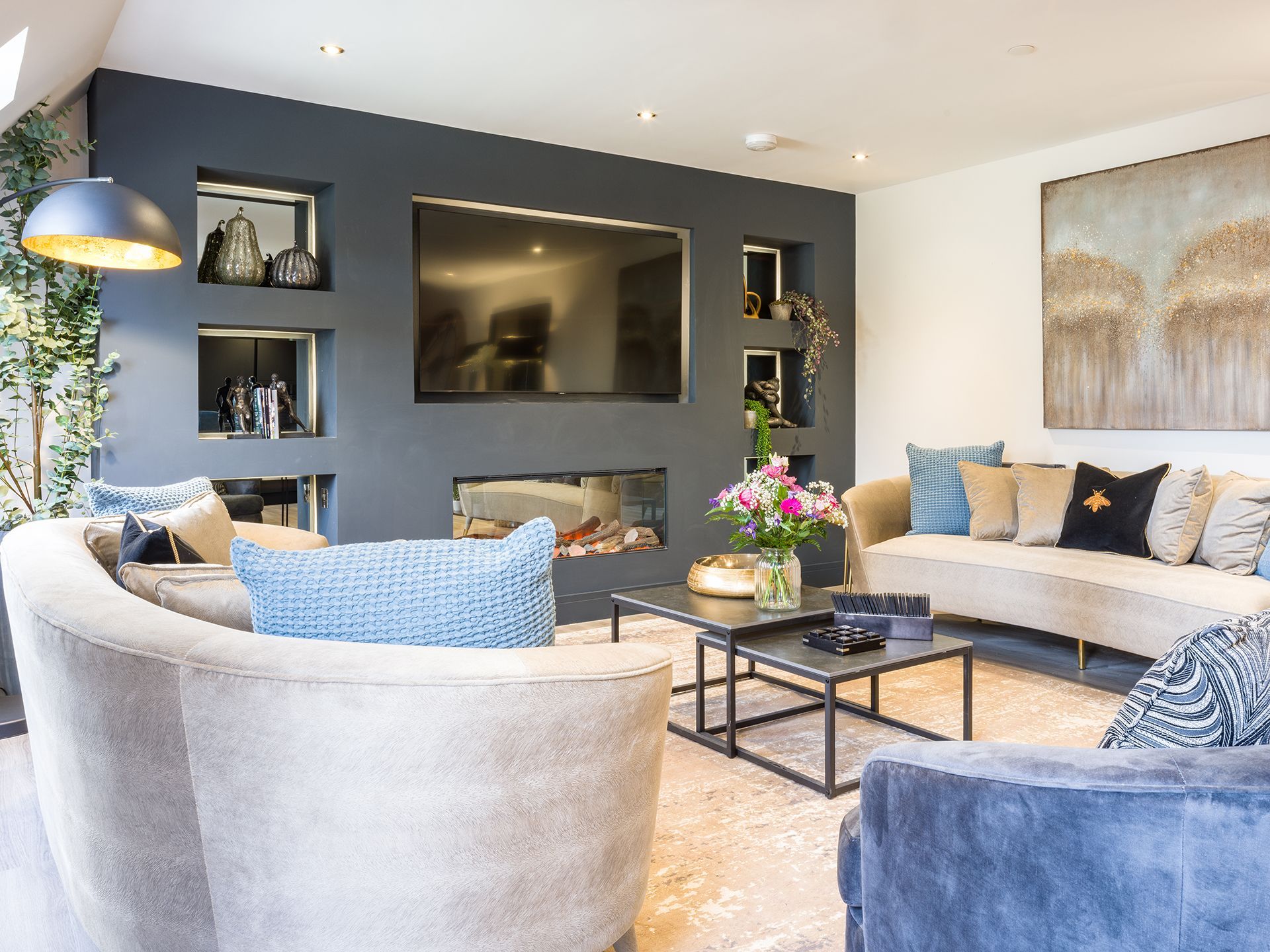 A living room with a couch , chairs , coffee table and television.