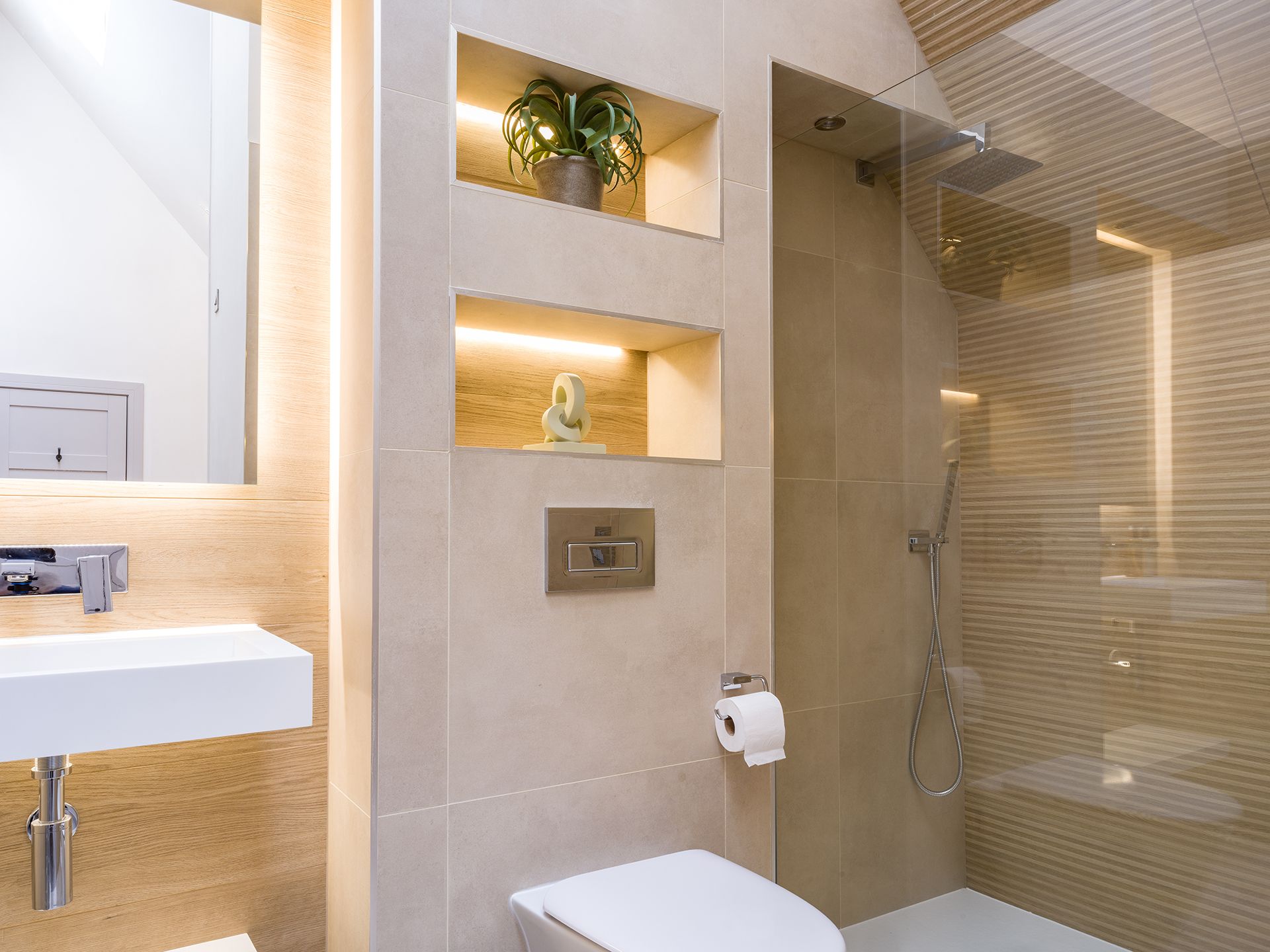 A bathroom with a toilet , sink , mirror and walk in shower.