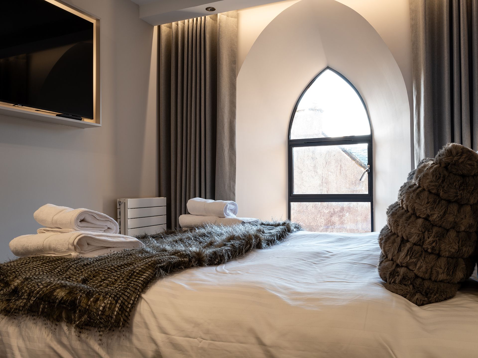 A bedroom with a large bed and a large window