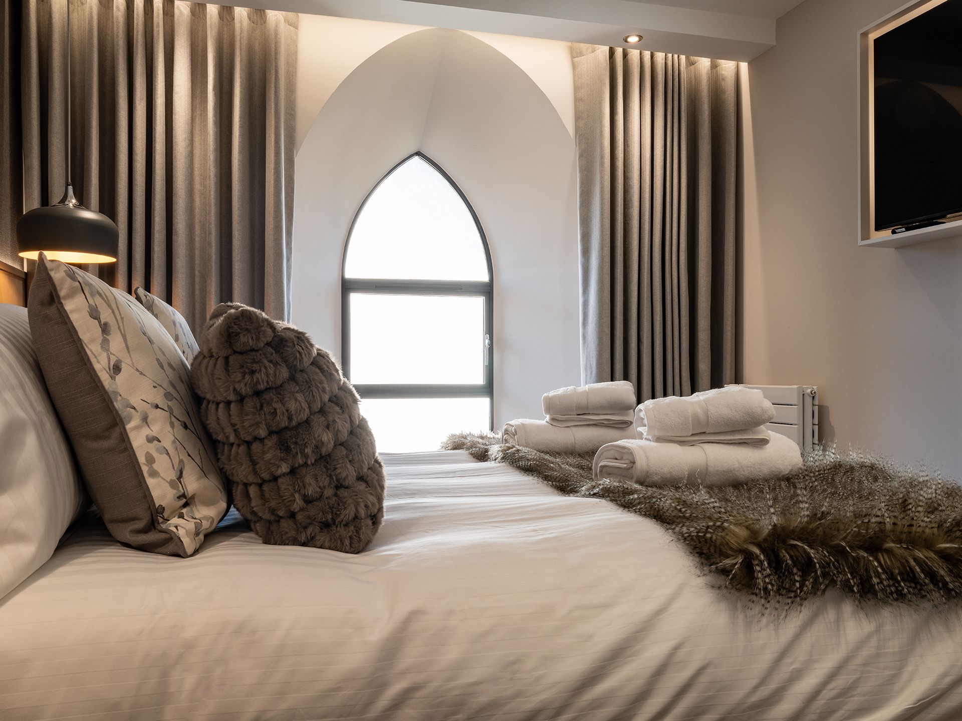 A bedroom with a bed and a window with curtains