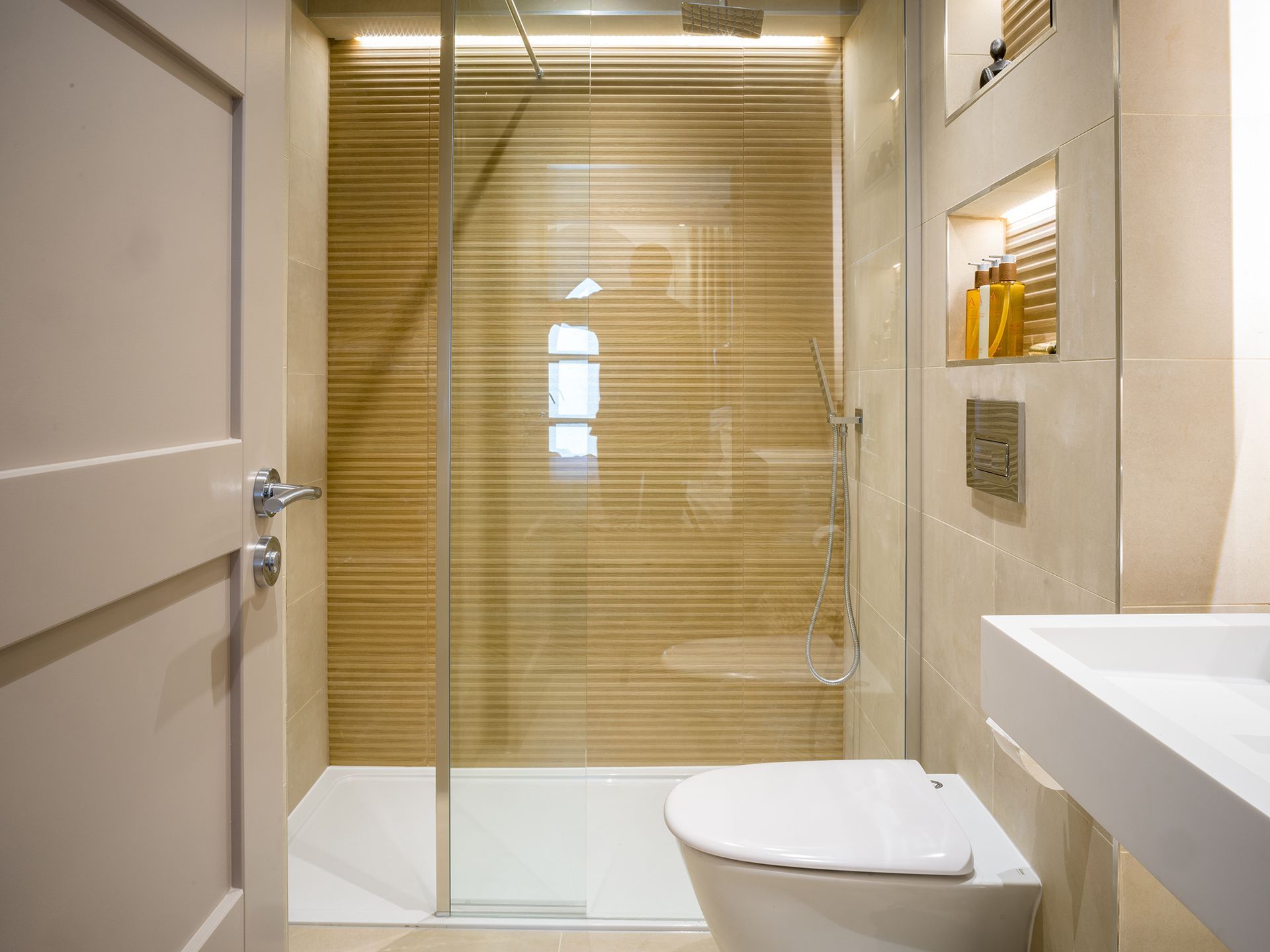 A bathroom with a toilet , sink and walk in shower.