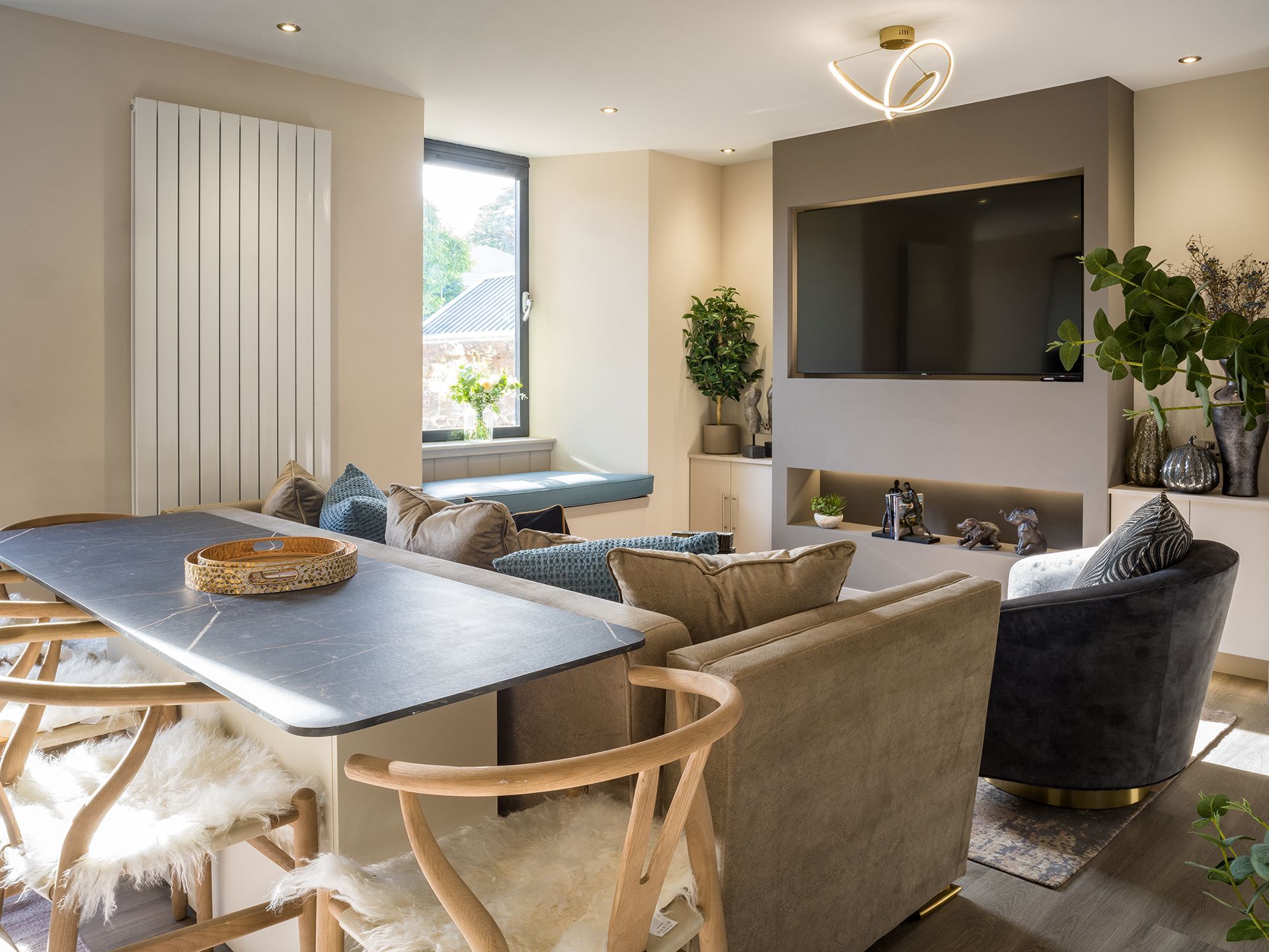 A living room with a couch , chairs , table and television.