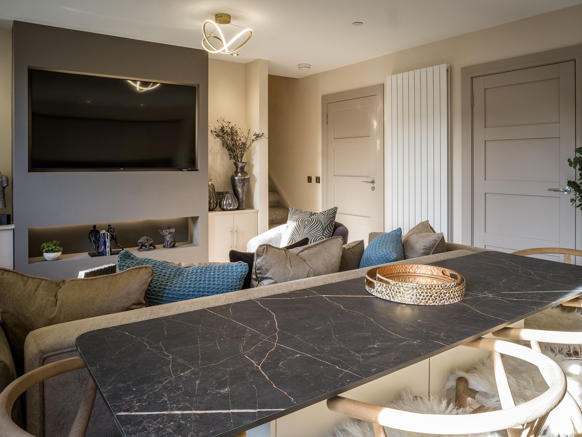 A living room with a table and chairs and a flat screen tv.