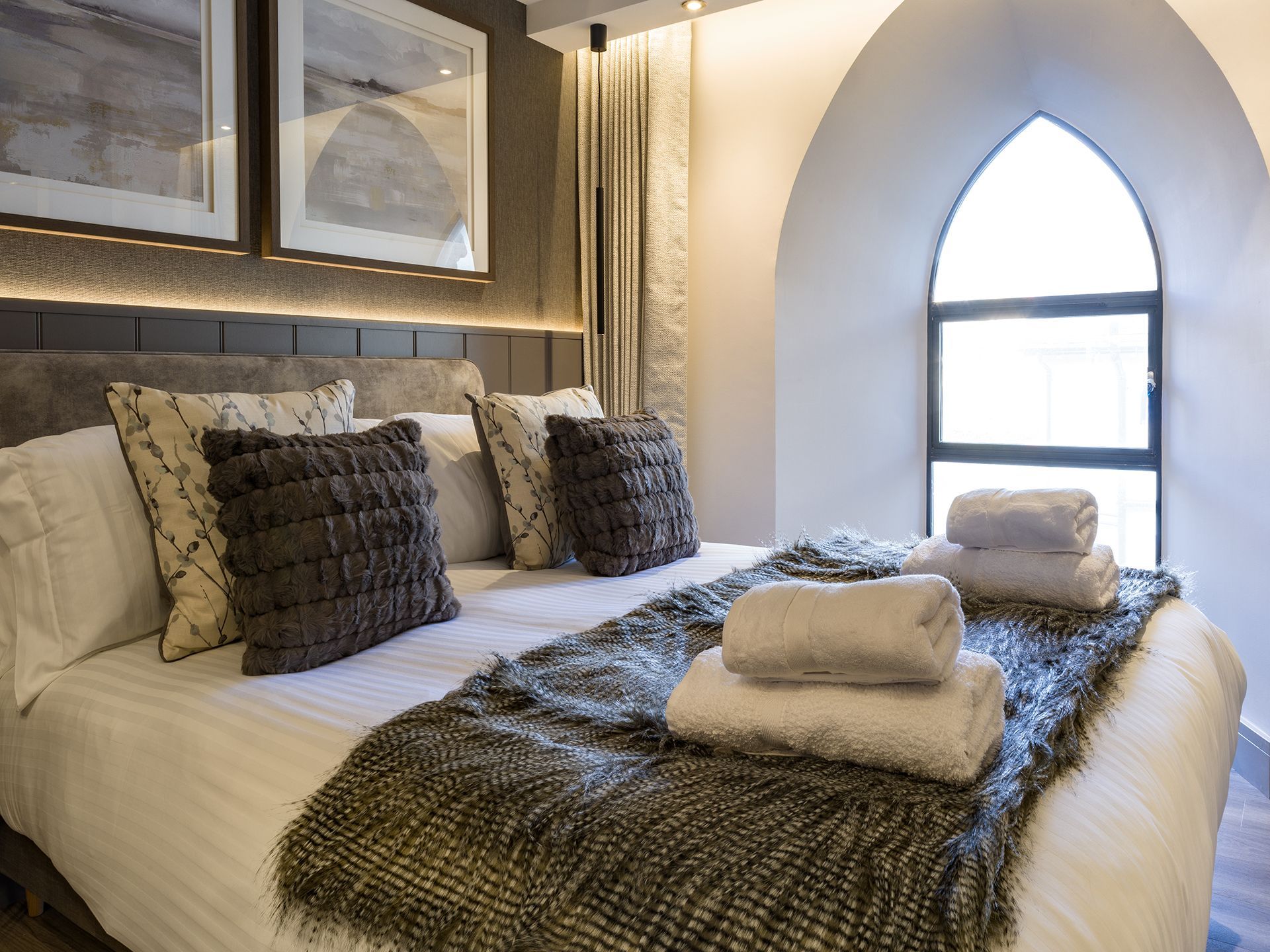 A bedroom with a large bed and a window.