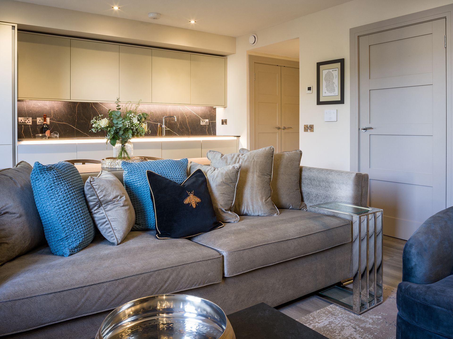 A living room with a gray couch and blue pillows