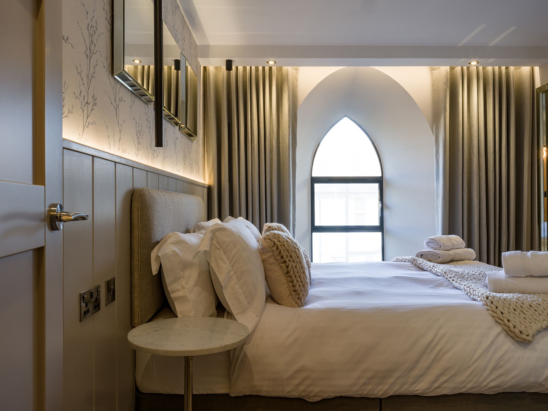 A hotel room with a large bed and a window.