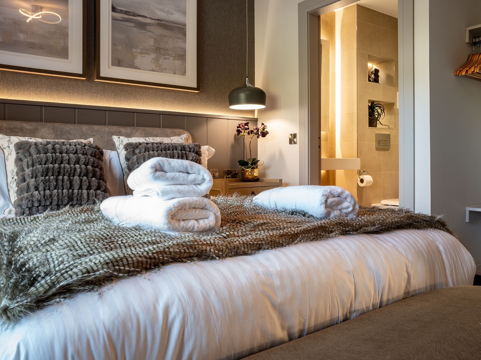A bedroom with a king size bed and towels on the bed.