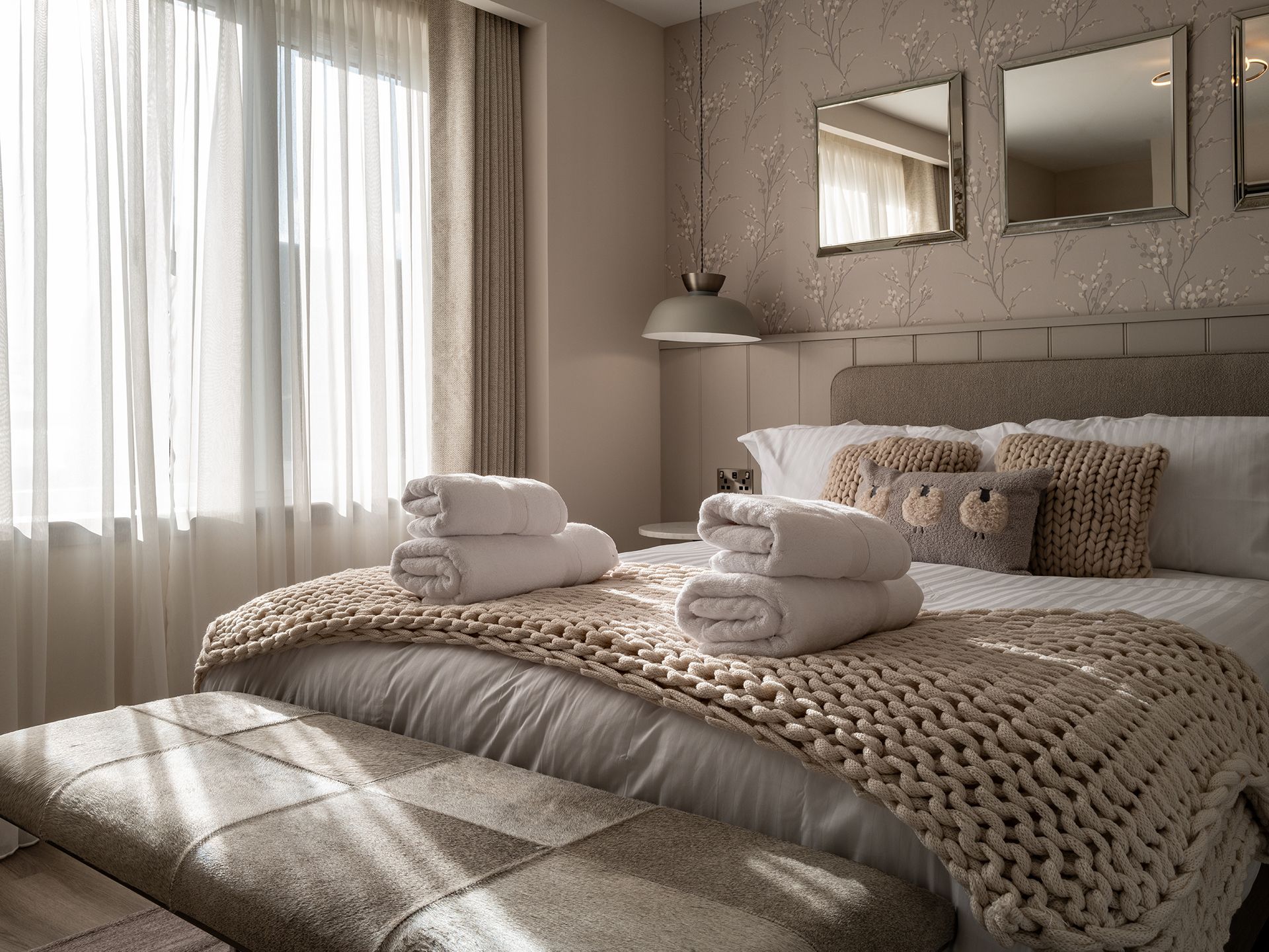 A bedroom with two beds , two mirrors and a window.