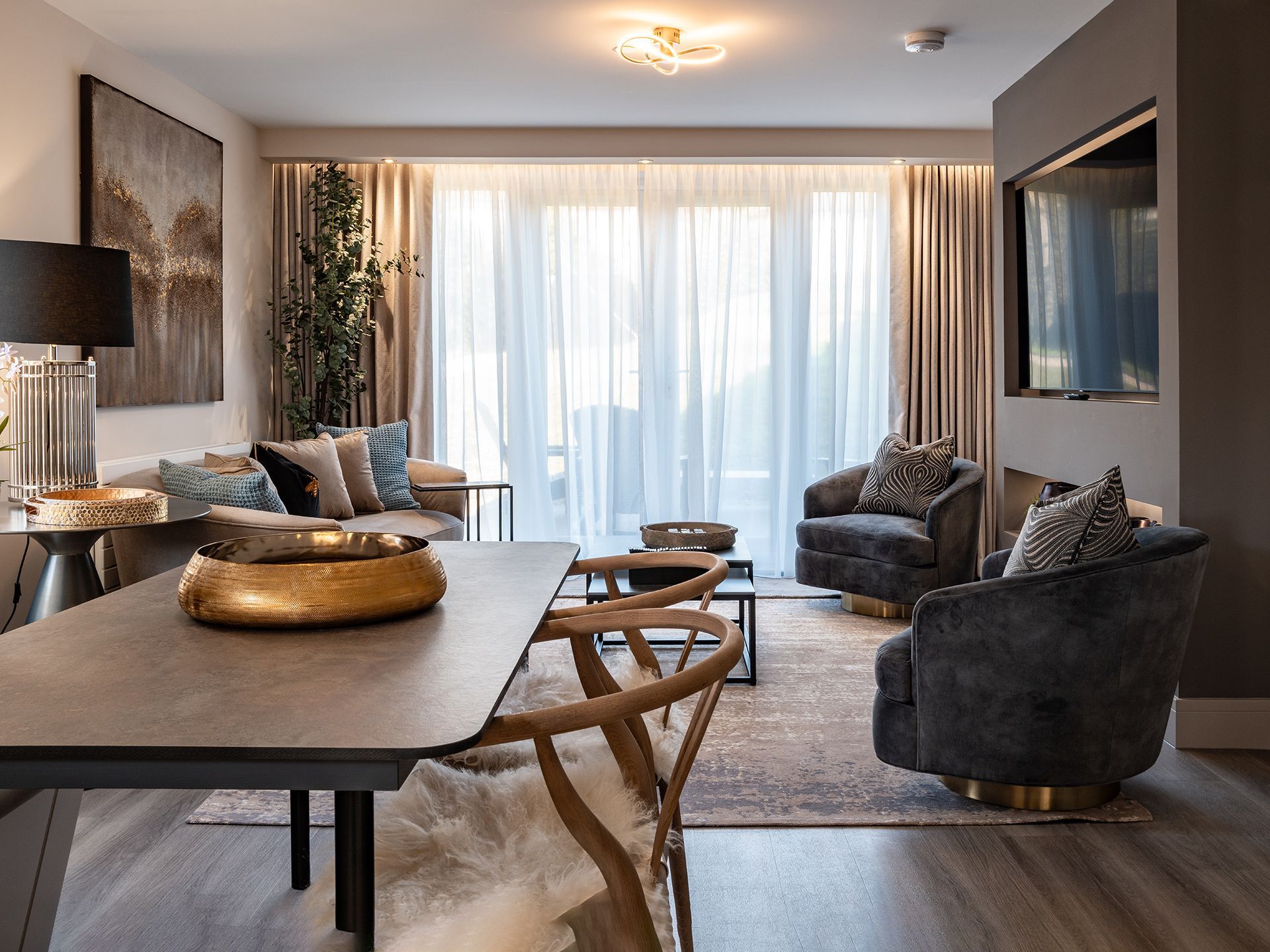 A living room with a table , chairs , a couch and a television.