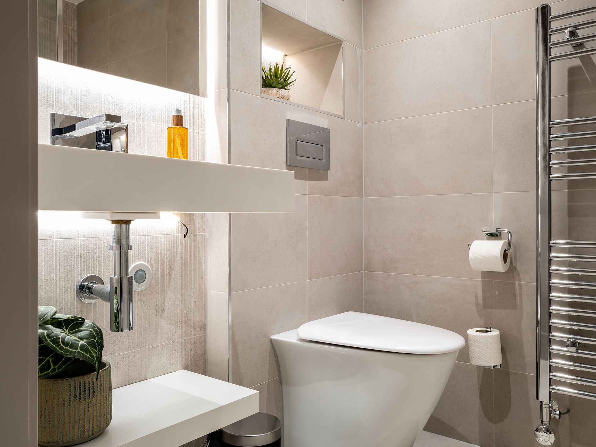 A bathroom with a toilet , sink , and towel rack.