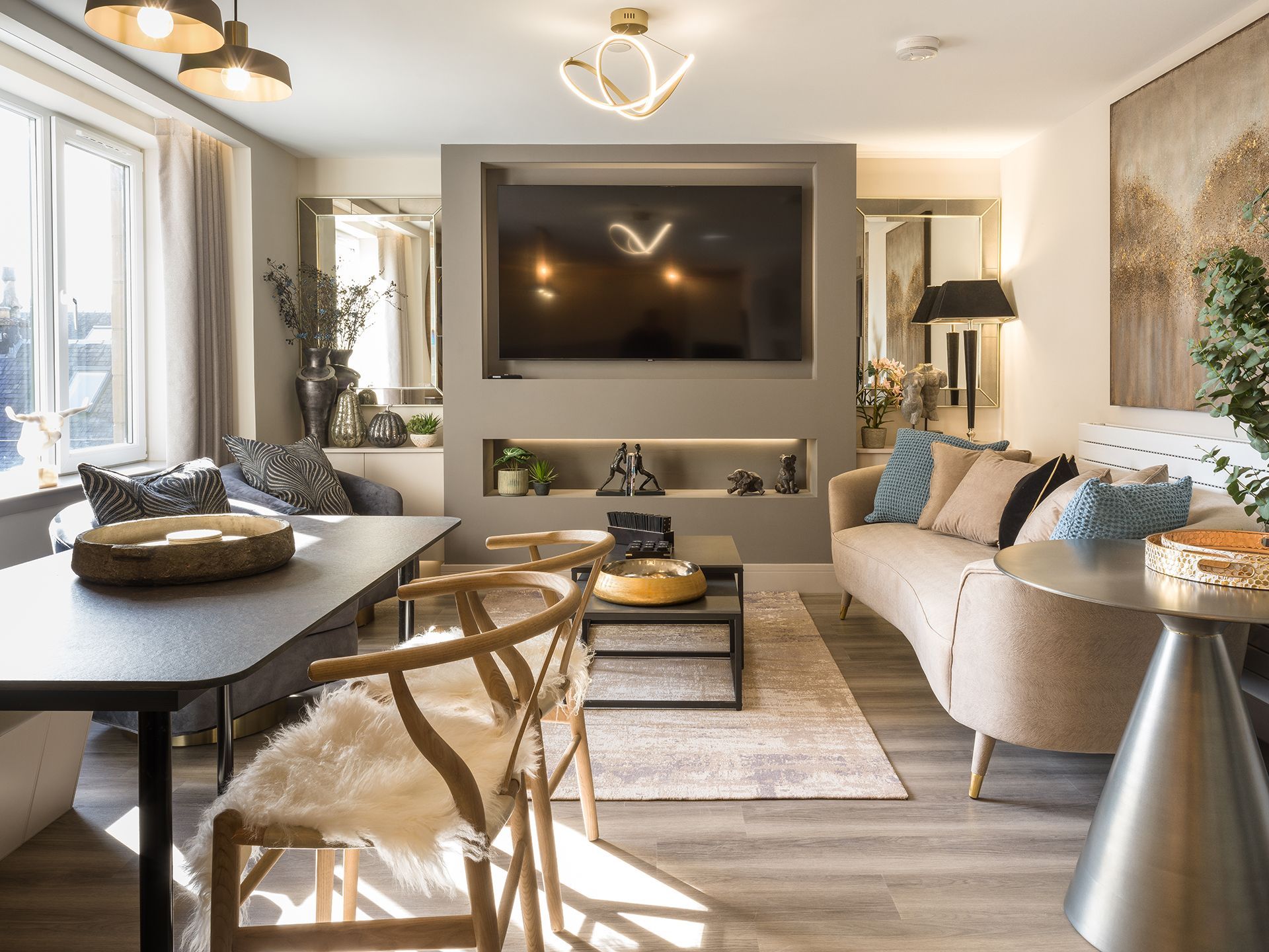 A living room with a couch , table , chairs and a flat screen tv.