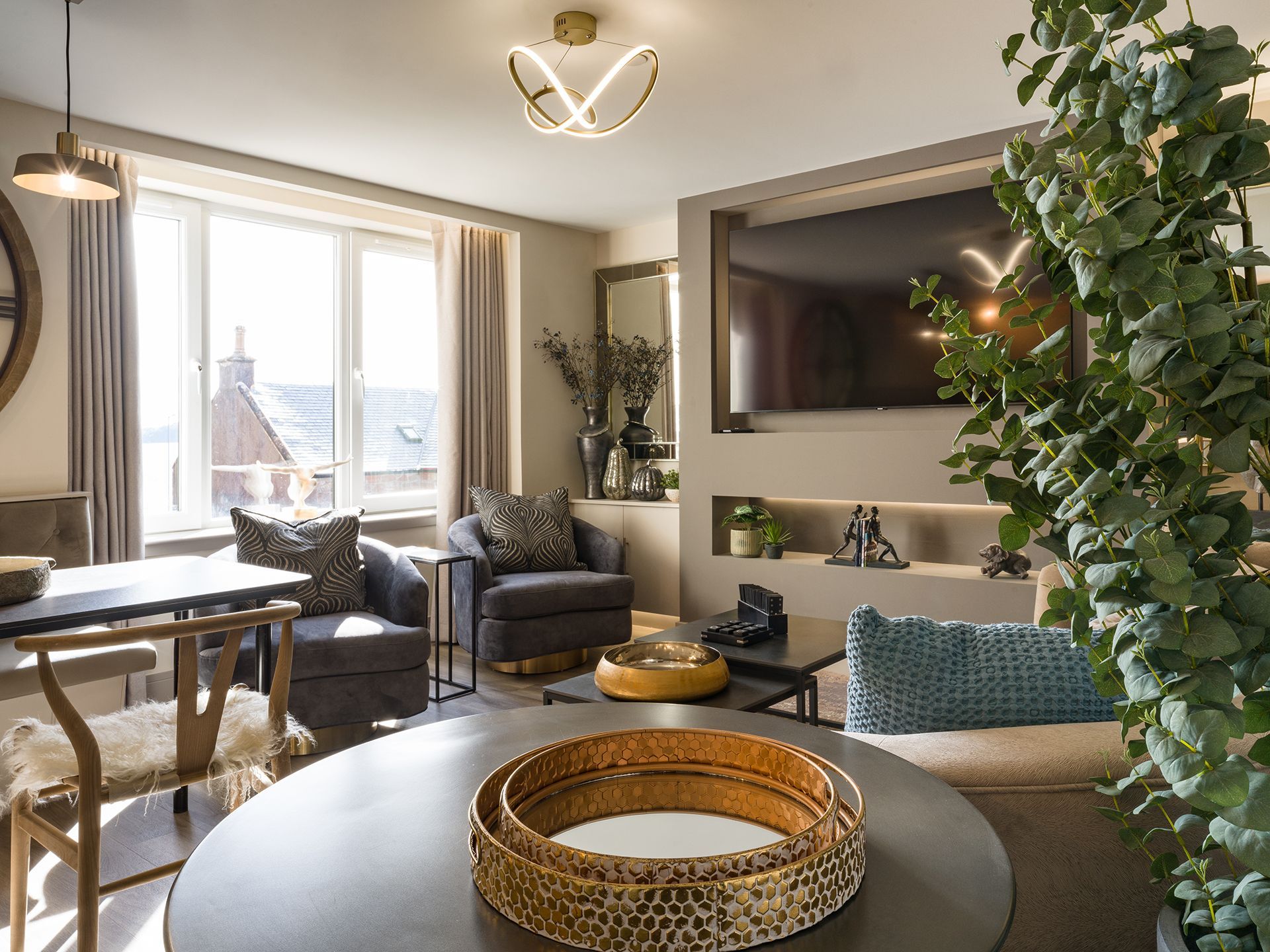 A living room with a table , chairs , and a flat screen tv.