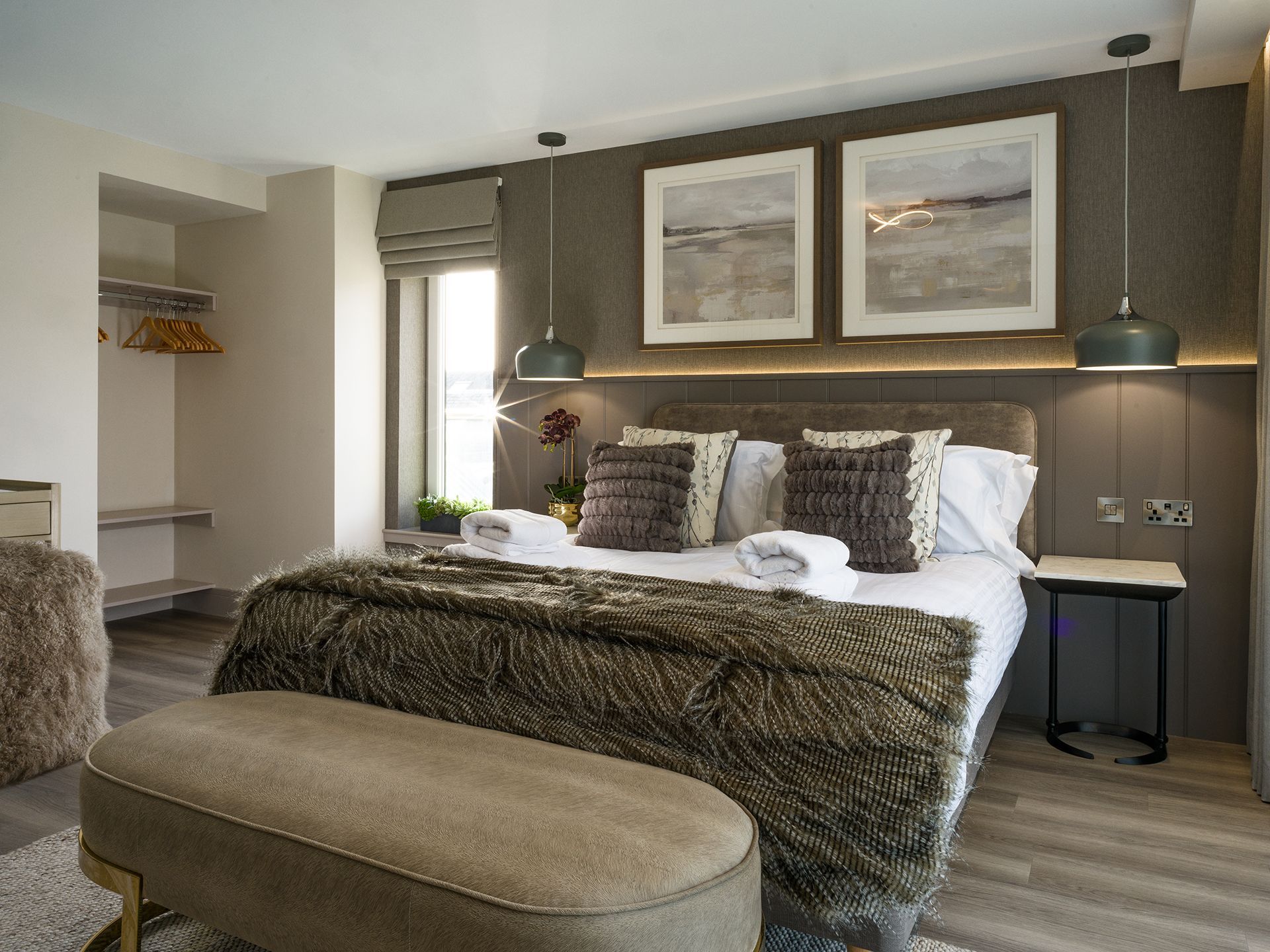 A bedroom with a large bed and a bench