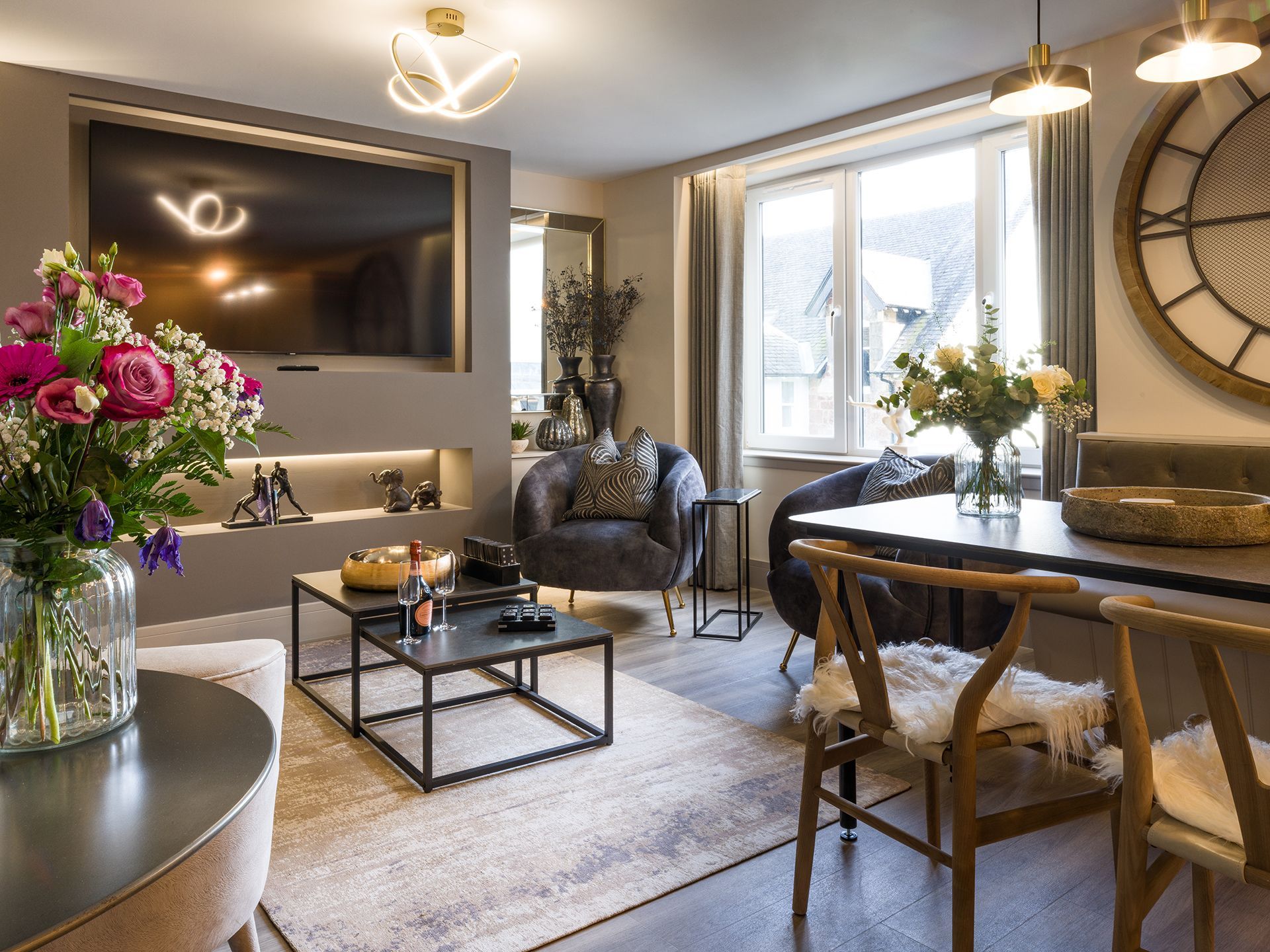 A living room with a table , chairs , coffee table and television.