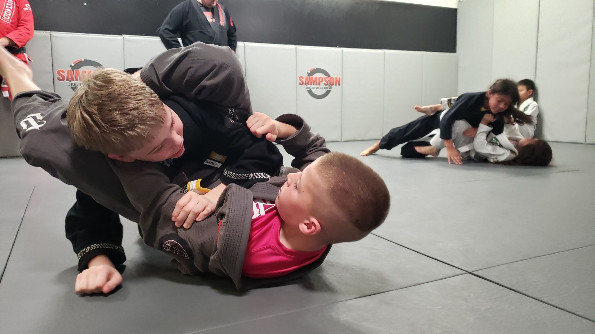 A group of people are practicing martial arts in a gym.