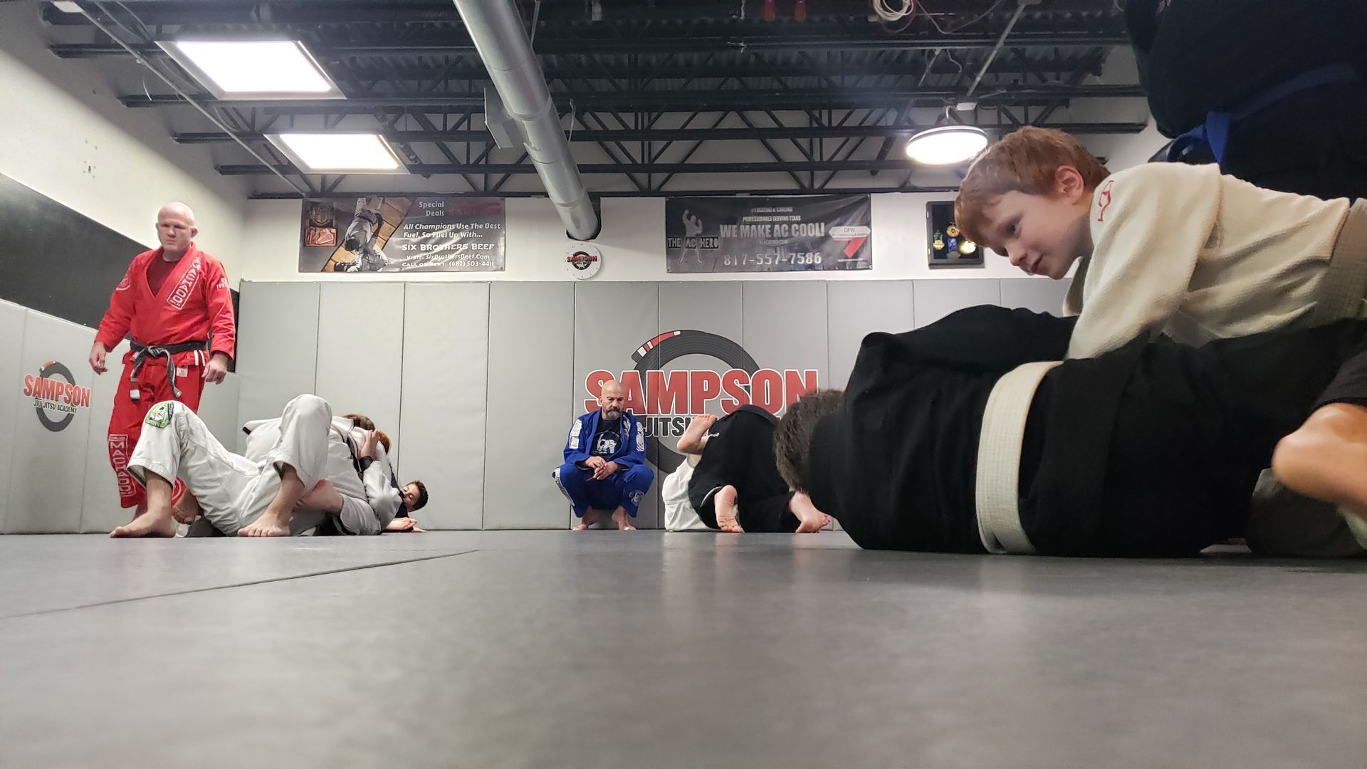 A group of people are practicing martial arts in a gym.