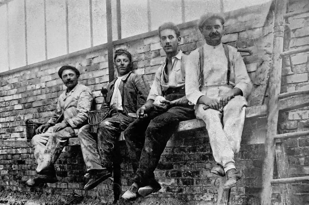 Un groupe d'hommes sont assis sur un mur de briques.