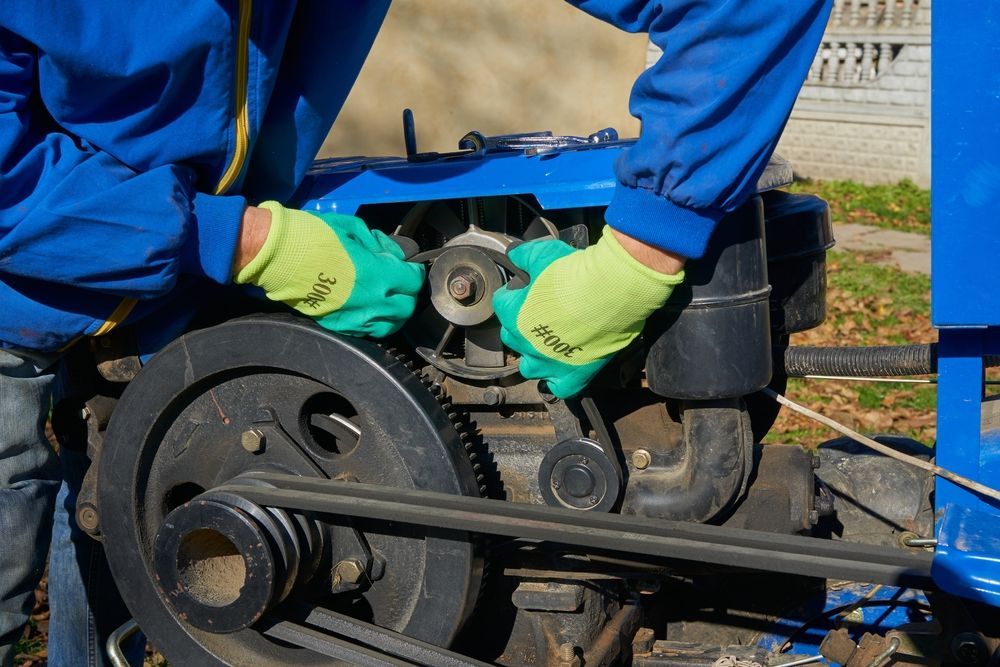 A Man Wearing Green Gloves is Working on a Machine — Coffs Harbour Bearing Centre in Coffs Harbour, NSW