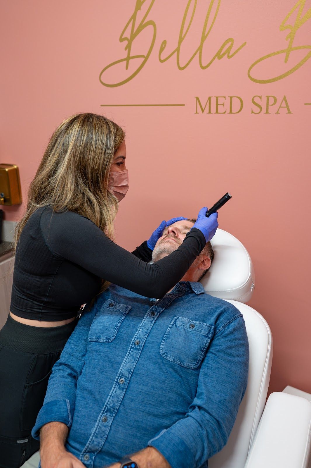 A woman is applying botox to a man 's face.