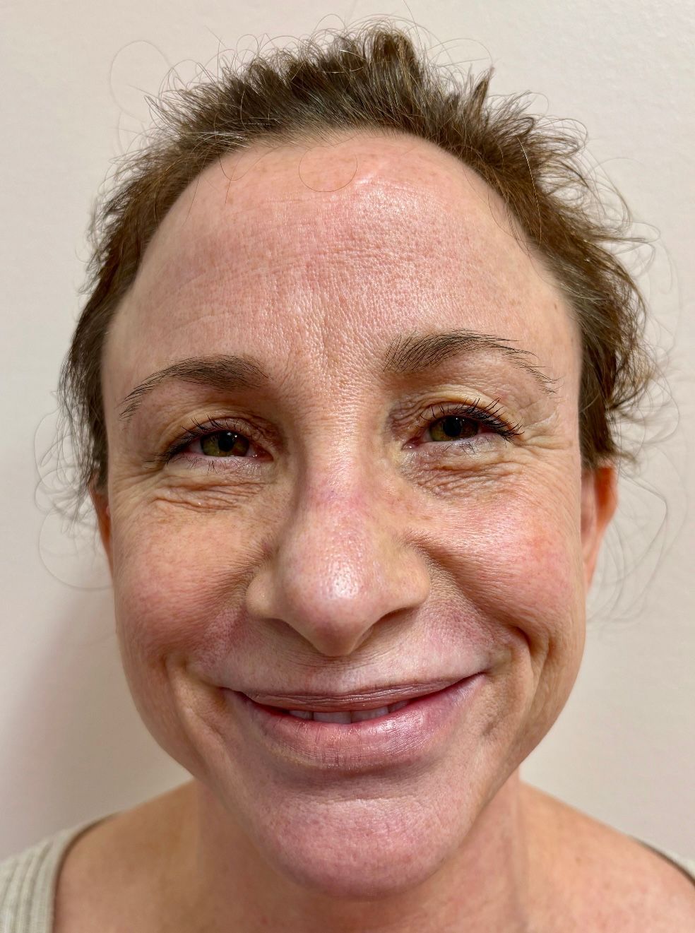 A close up of a woman 's face with a smile on her face.