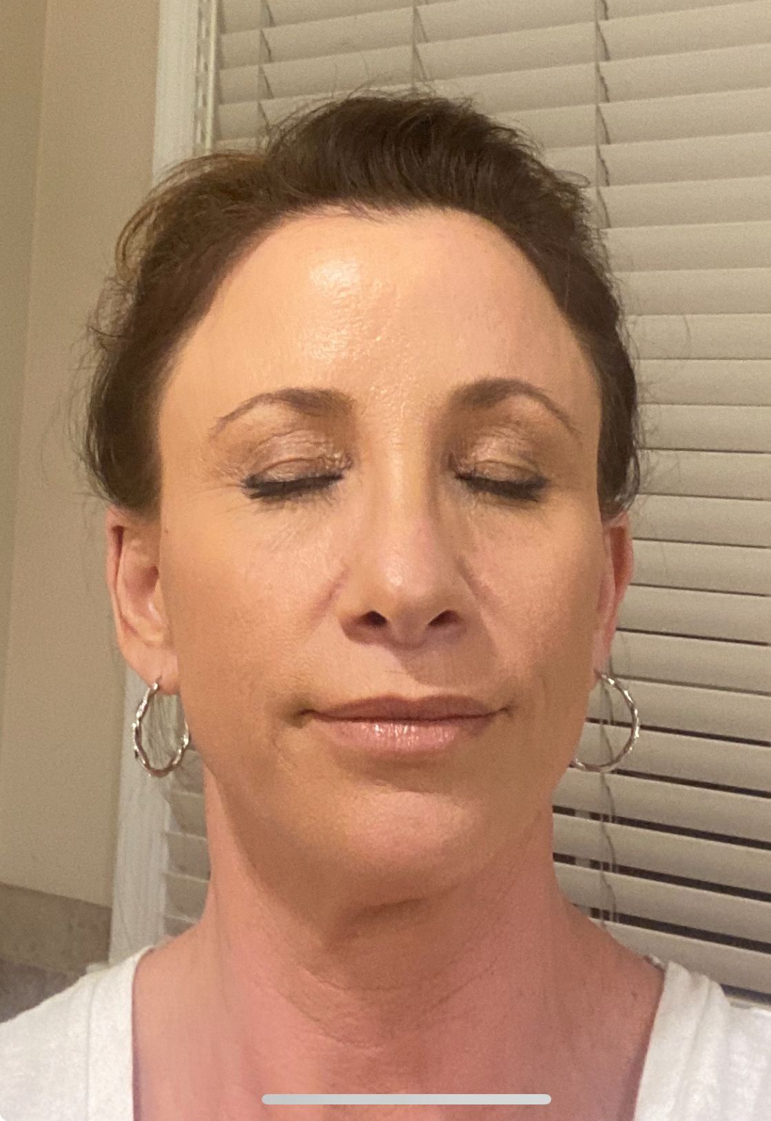 A close up of a woman 's face with her eyes closed.