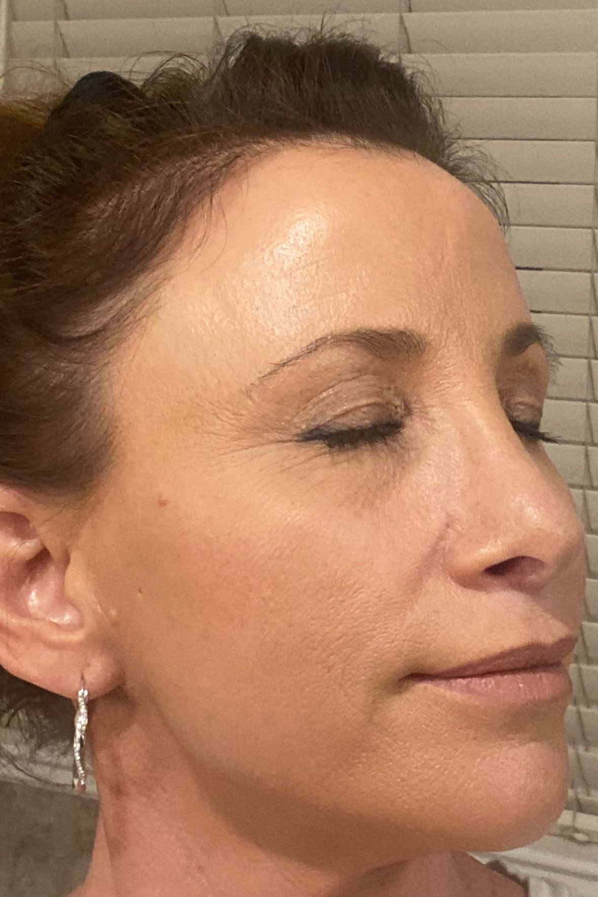 A close up of a woman 's face with earrings on.