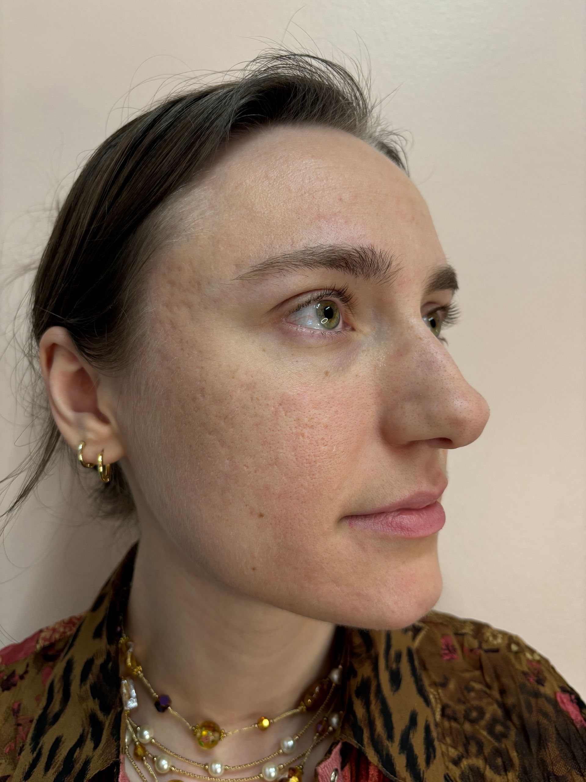 A close up of a woman 's face wearing a necklace and earrings.