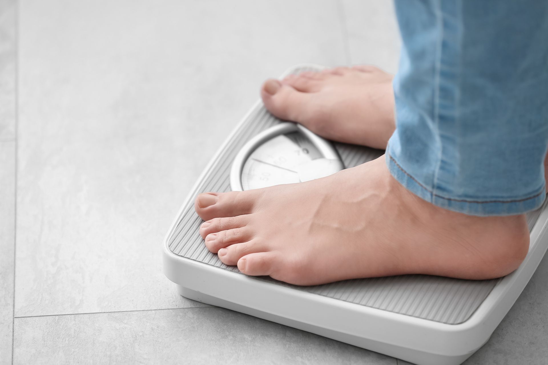 A person is standing on a scale with their feet on it.