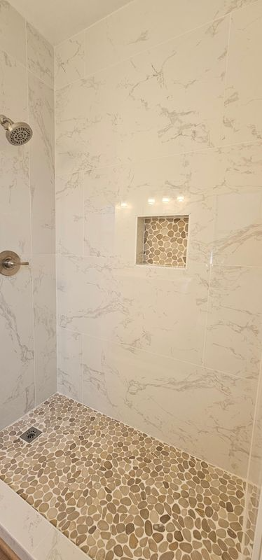 Tile shower wall with built-in square niche and mosaic floor tile