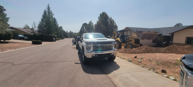 White pickup truck parked on a sunny suburban street near houses and dry landscaping