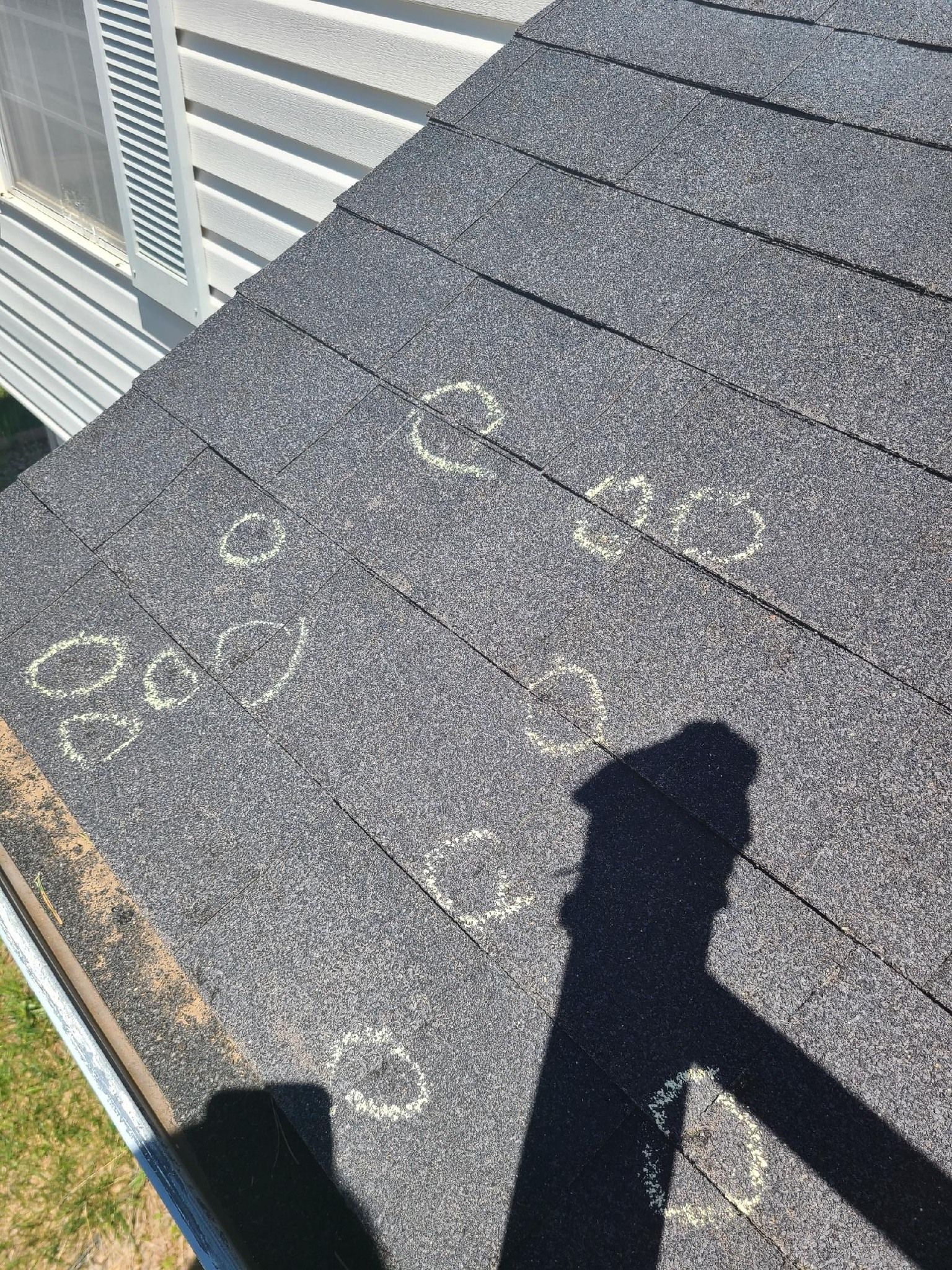A close up of a roof with a shadow of a person on it.