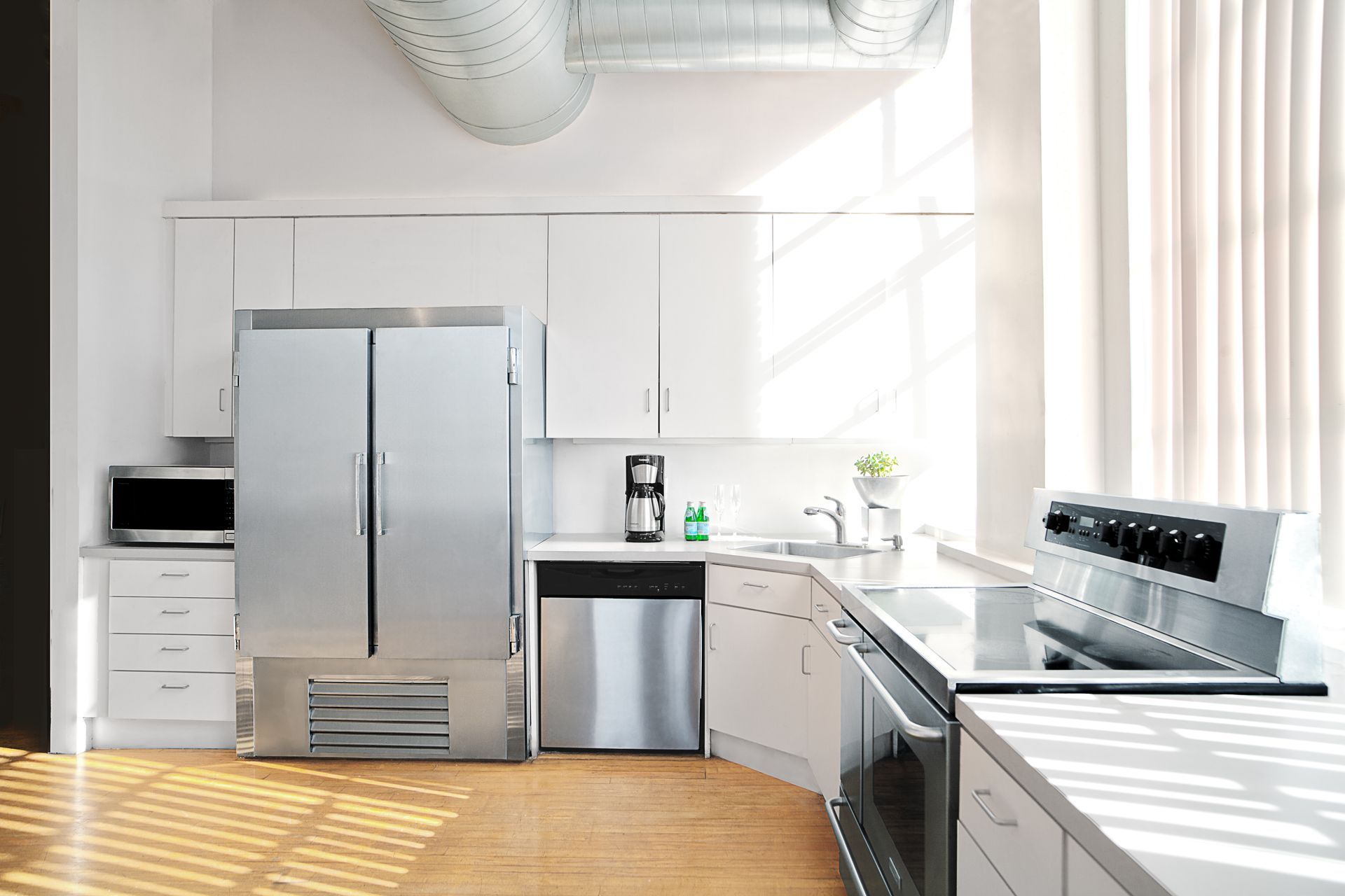 A kitchen with stainless steel appliances and white cabinets