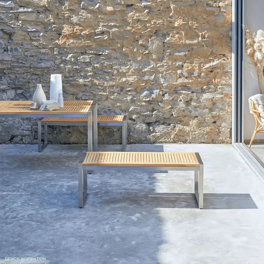 Outdoor Teak and Metal Furniture Set Against a Stone Wall — Highlander Metals in Kirrawee, NSW