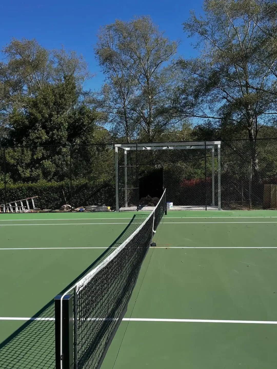 Tennis Court With Green Surface, Black Net, and a Backdrop Structure — Highlander Metals in Wollongong, NSW