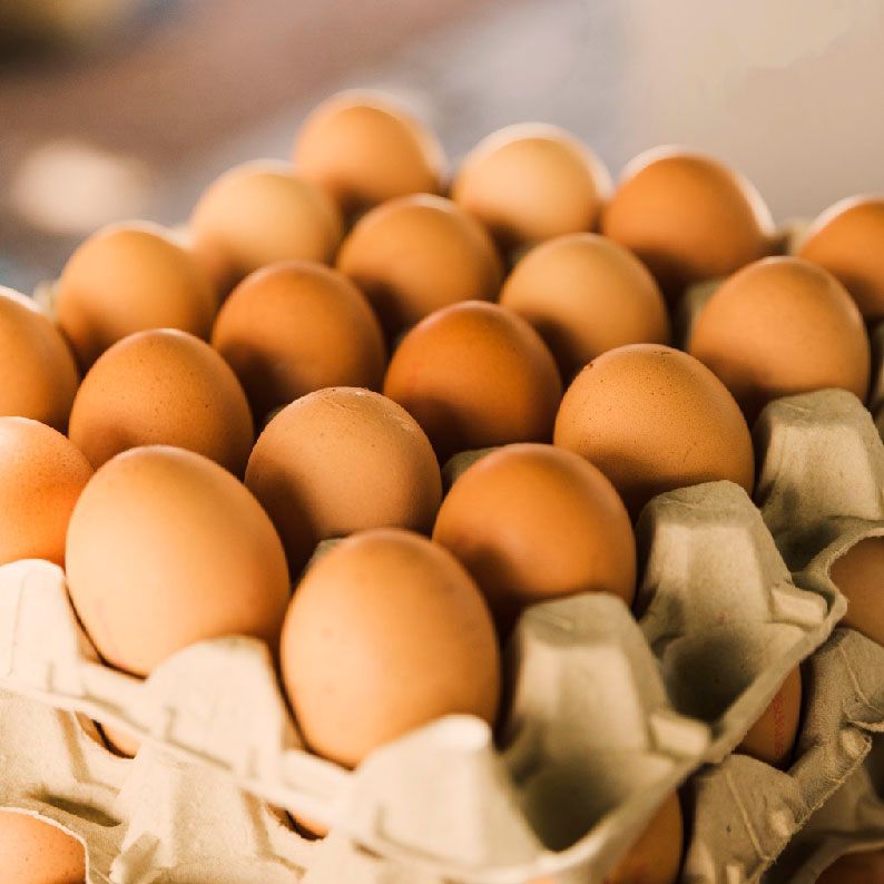 Un cartón de huevos marrones está sobre una mesa.