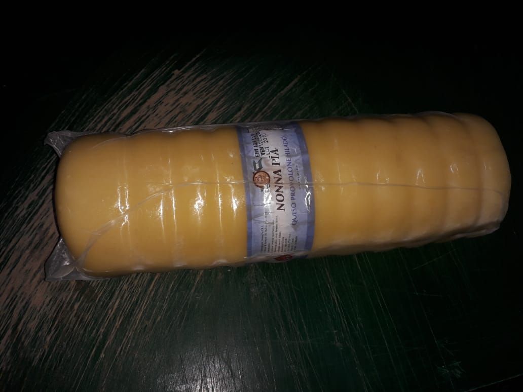 Un trozo largo de queso está envuelto en plástico.