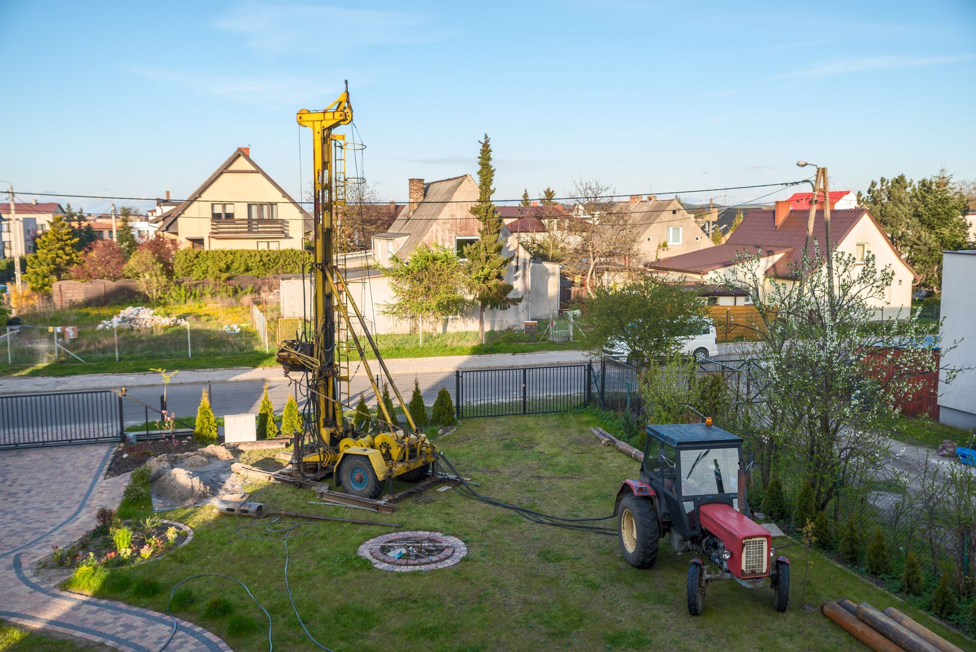 A machine performing residential well drilling to create a well at a residential property site