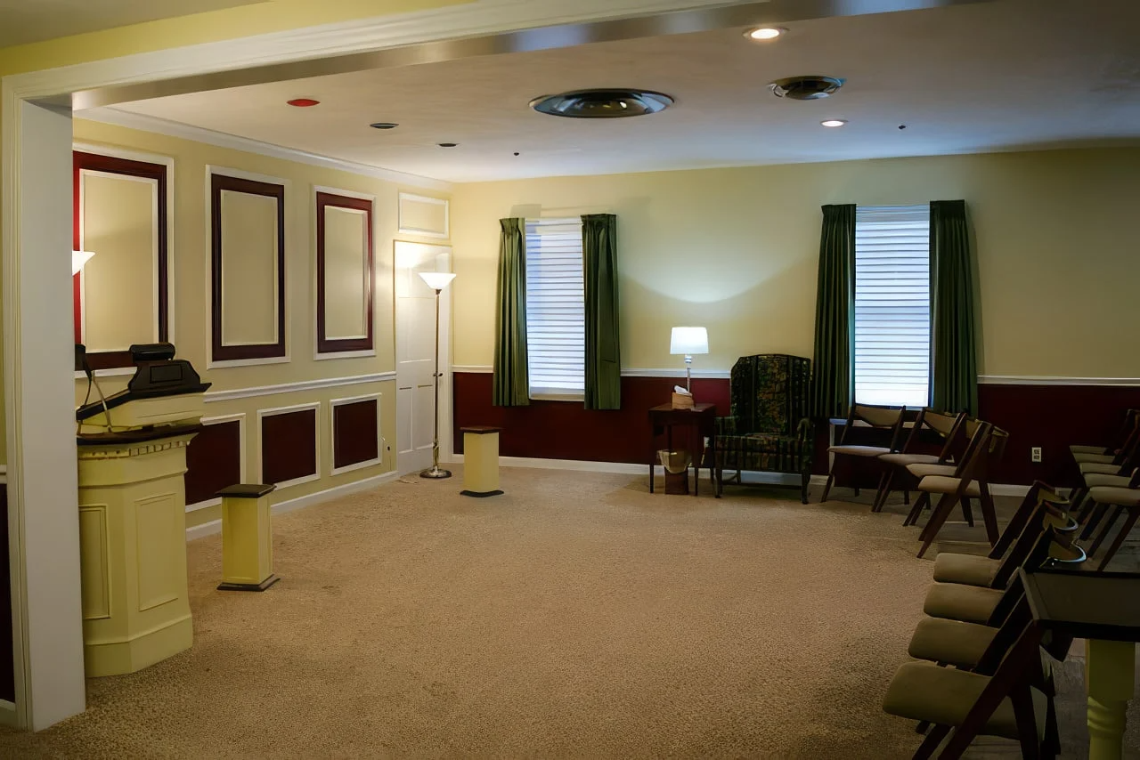 A large room with a podium and chairs in it.