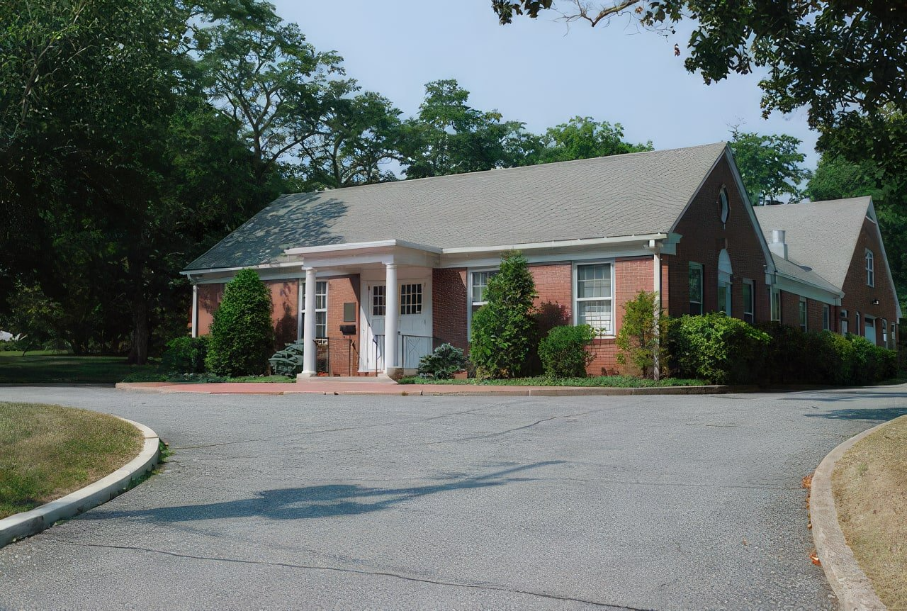 A brick house with a gray roof and white trim
