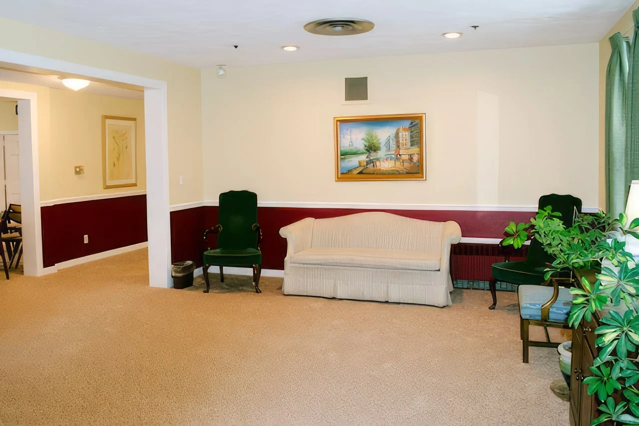 A living room with a couch and chairs and a picture on the wall