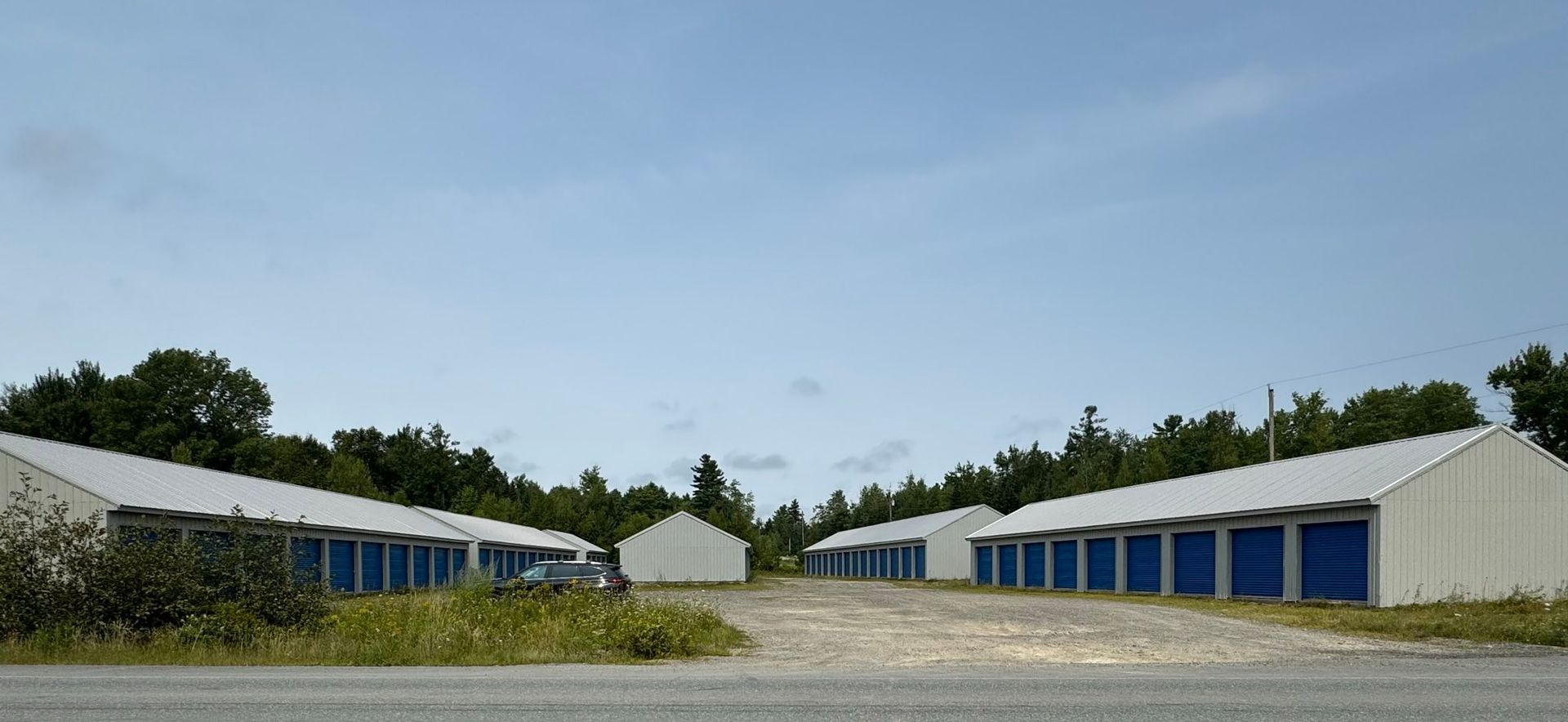 Wide view of six storage buildings from the road.