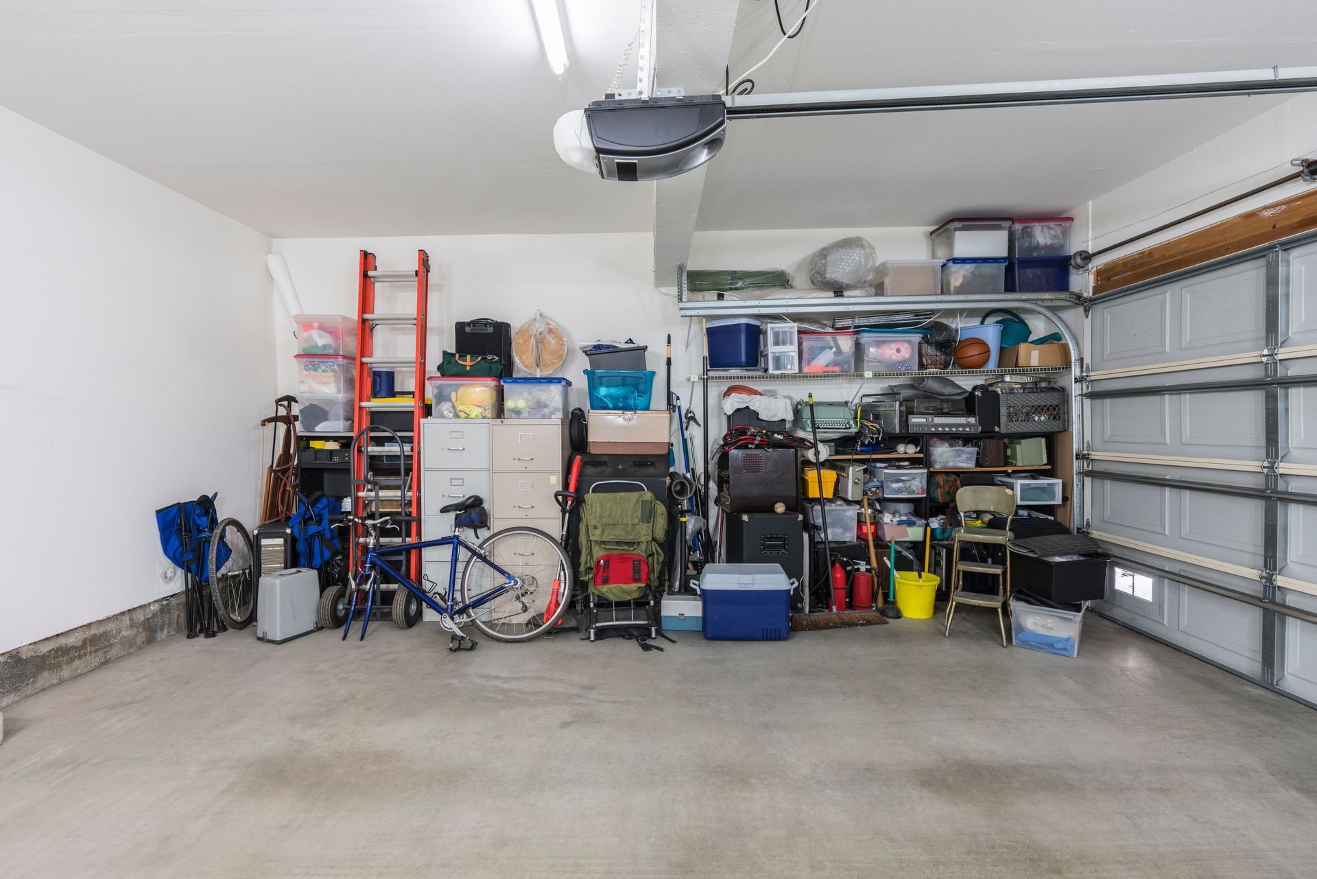 A garage filled with lots of items and a bicycle.