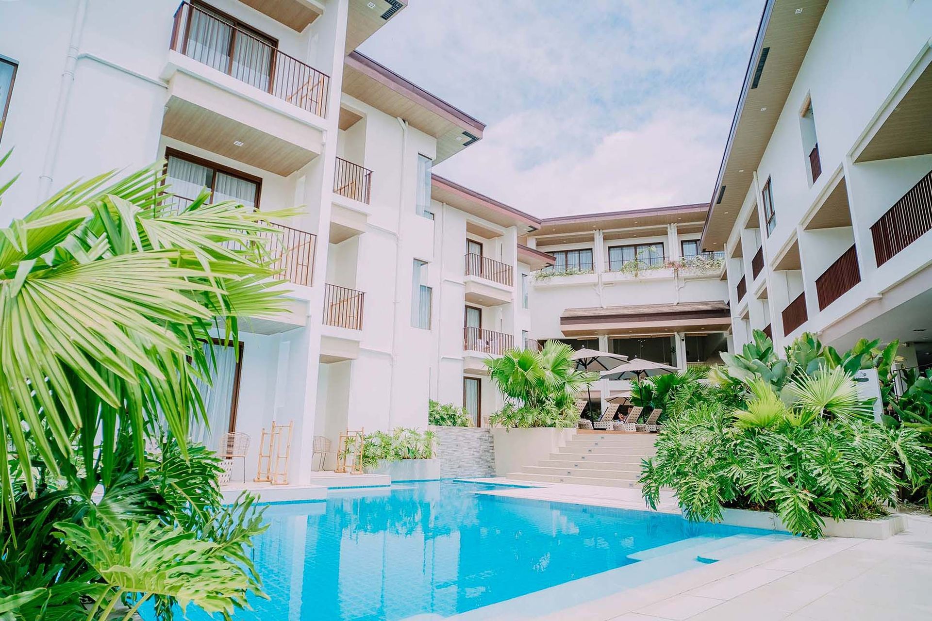 Charlie's El Nido resort outdoor pool with tropical gardens and balconies